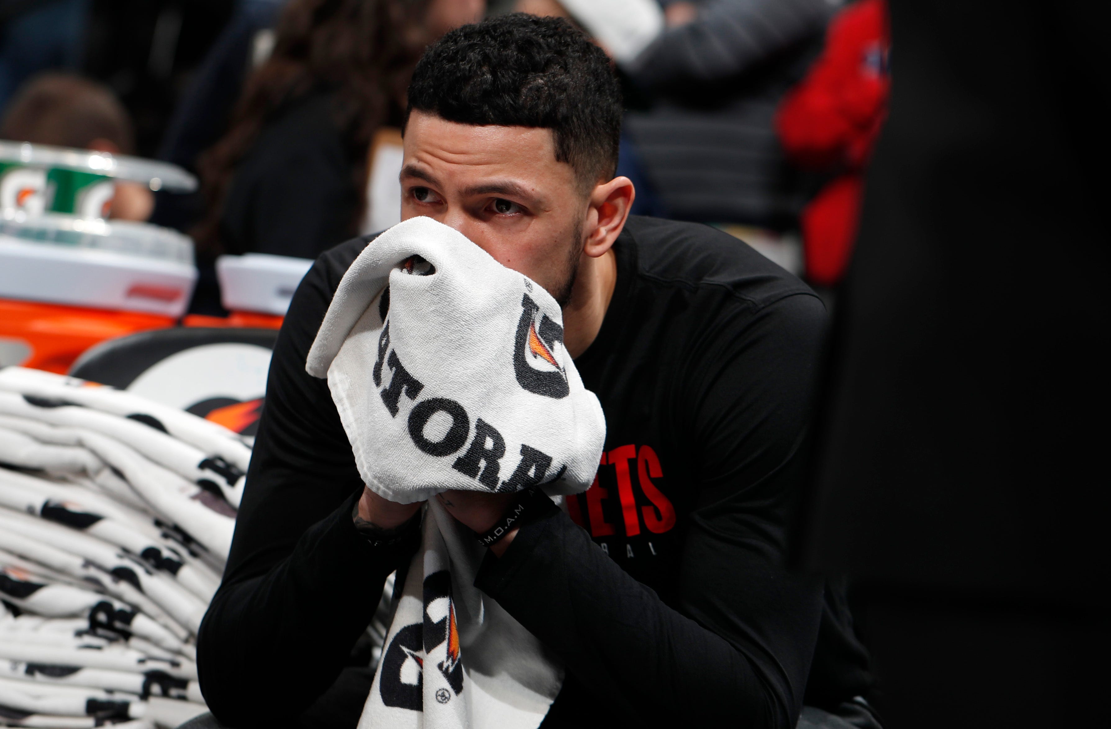 Houston Rockets guard Austin Rivers sits on the bench after word of the death of former NBA star Kobe Bryant.