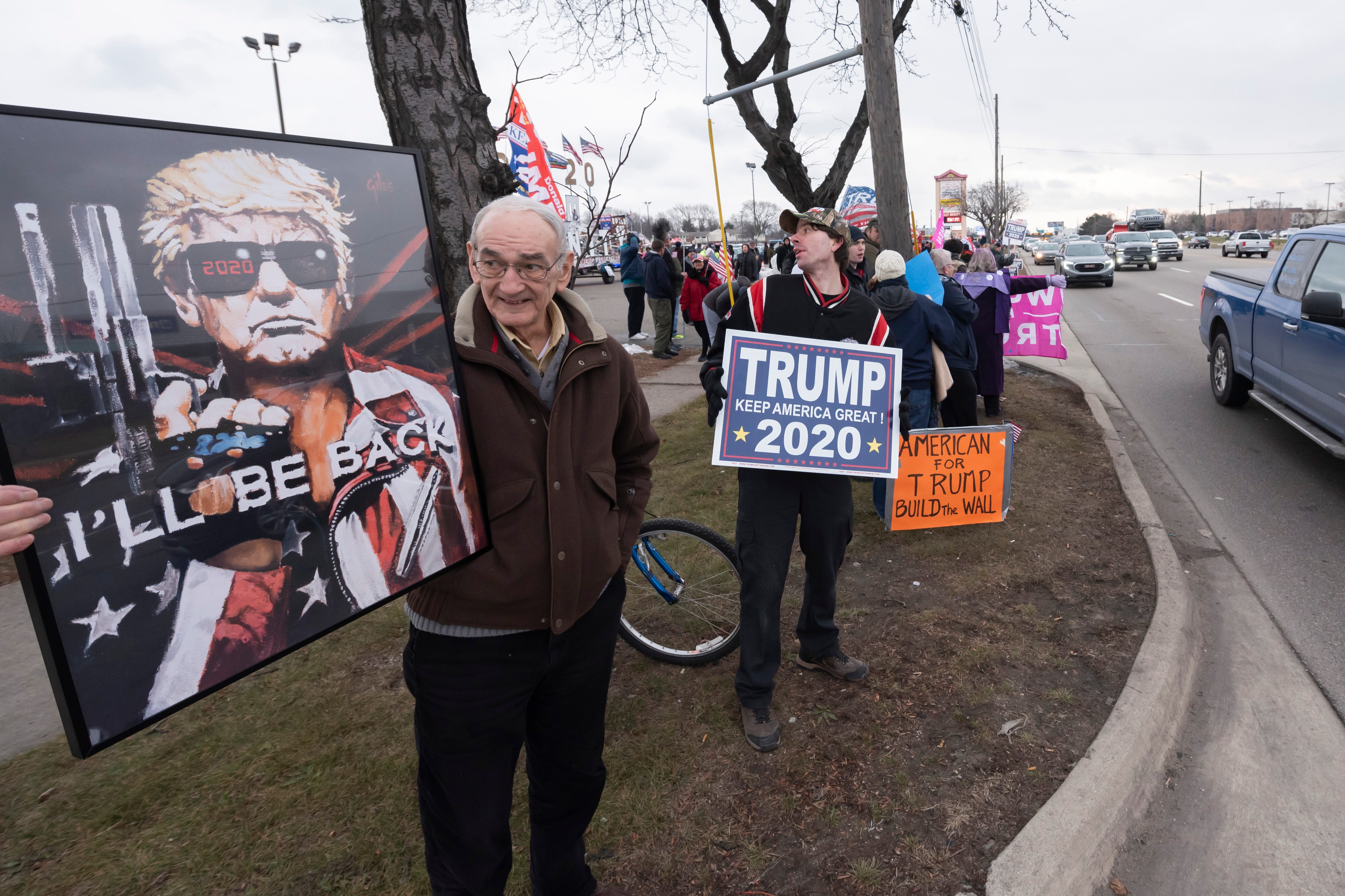 Supporters with signs and flags wait along Van Dyke for the arrival of President Donald Trump.