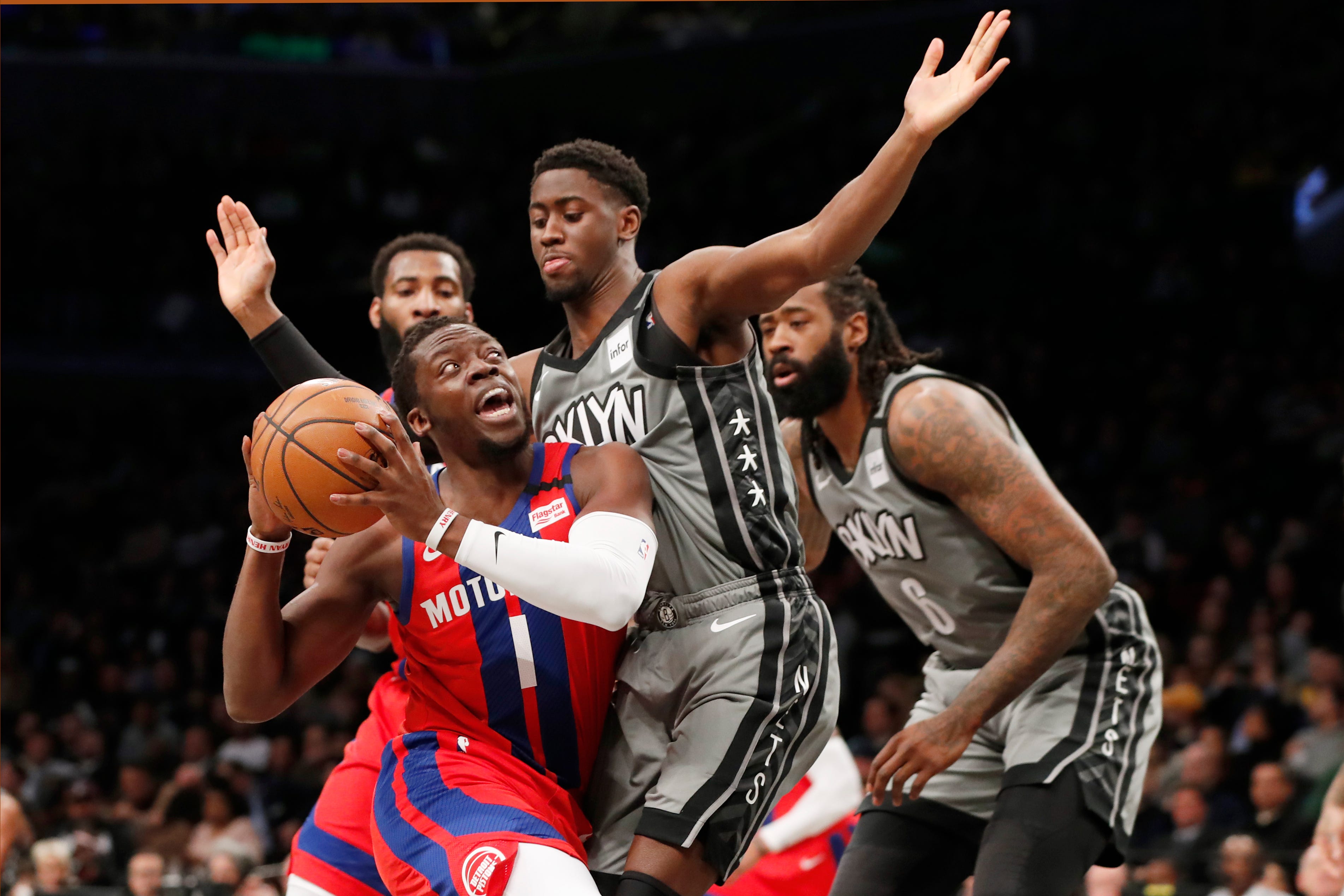 Detroit Pistons guard Reggie Jackson drives up against Brooklyn Nets guard Caris LeVert  as Nets center DeAndre Jordan watches during the first half in New York on Wednesday, Jan. 29, 2020.