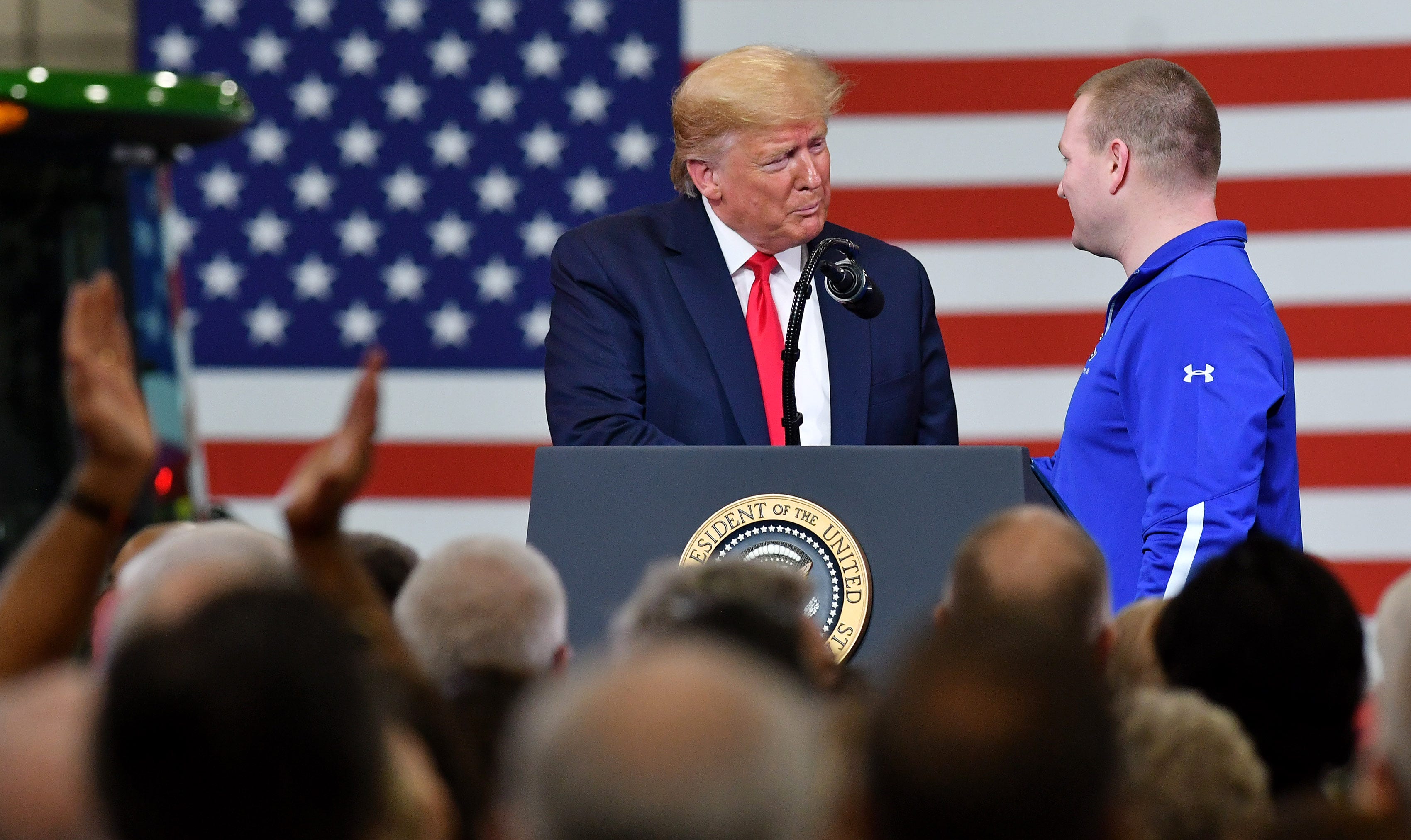 President Donald Trump shakes hands with Dana production supervisor and military veteran Devin Mallory, 34, of Washington Township during the President's remarks at Dana Incorporated in Warren, Mich. on Jan. 30, 2020.