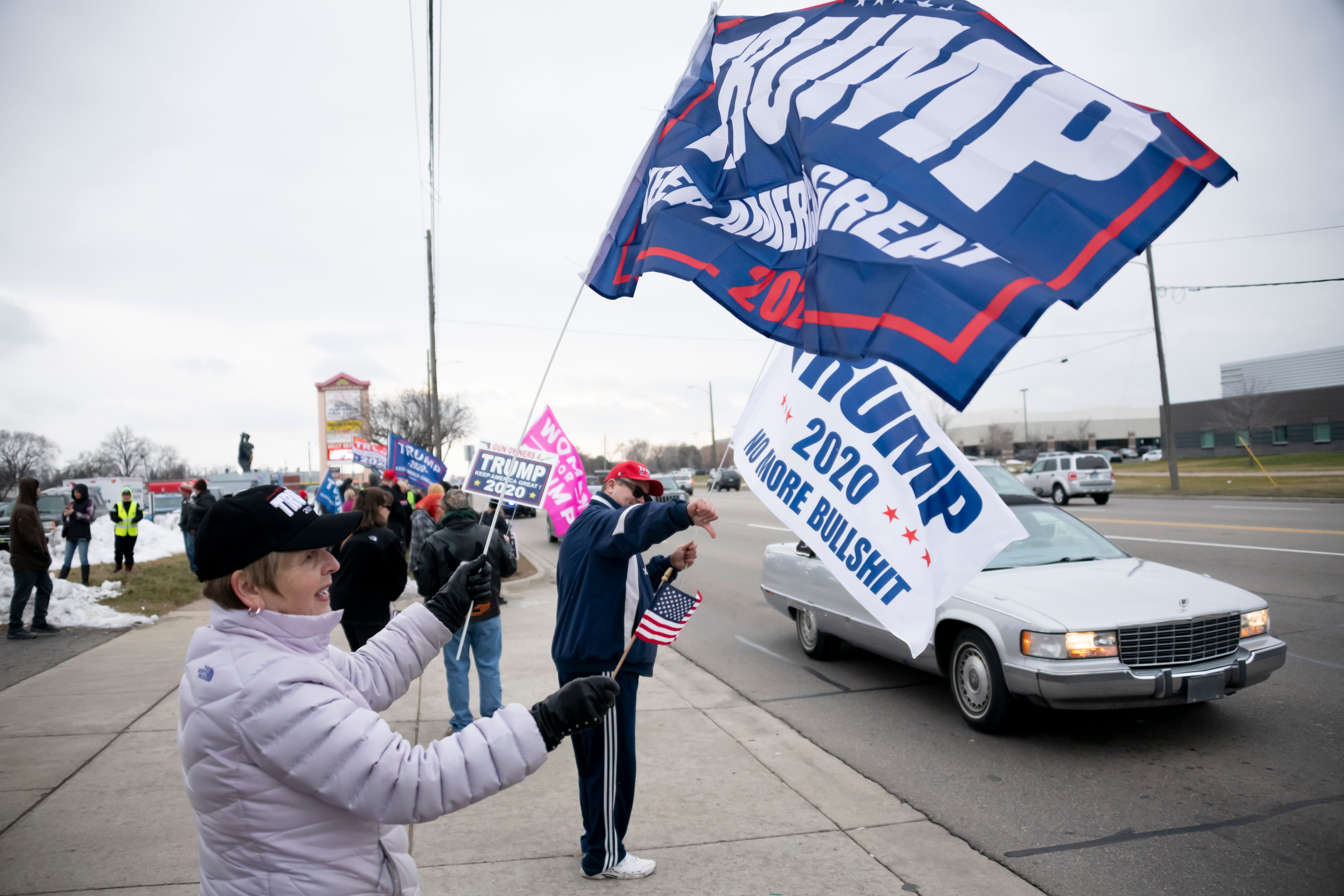 Supporters wave signs and flags while waiting along Van Dyke for the arrival of the President Trump.