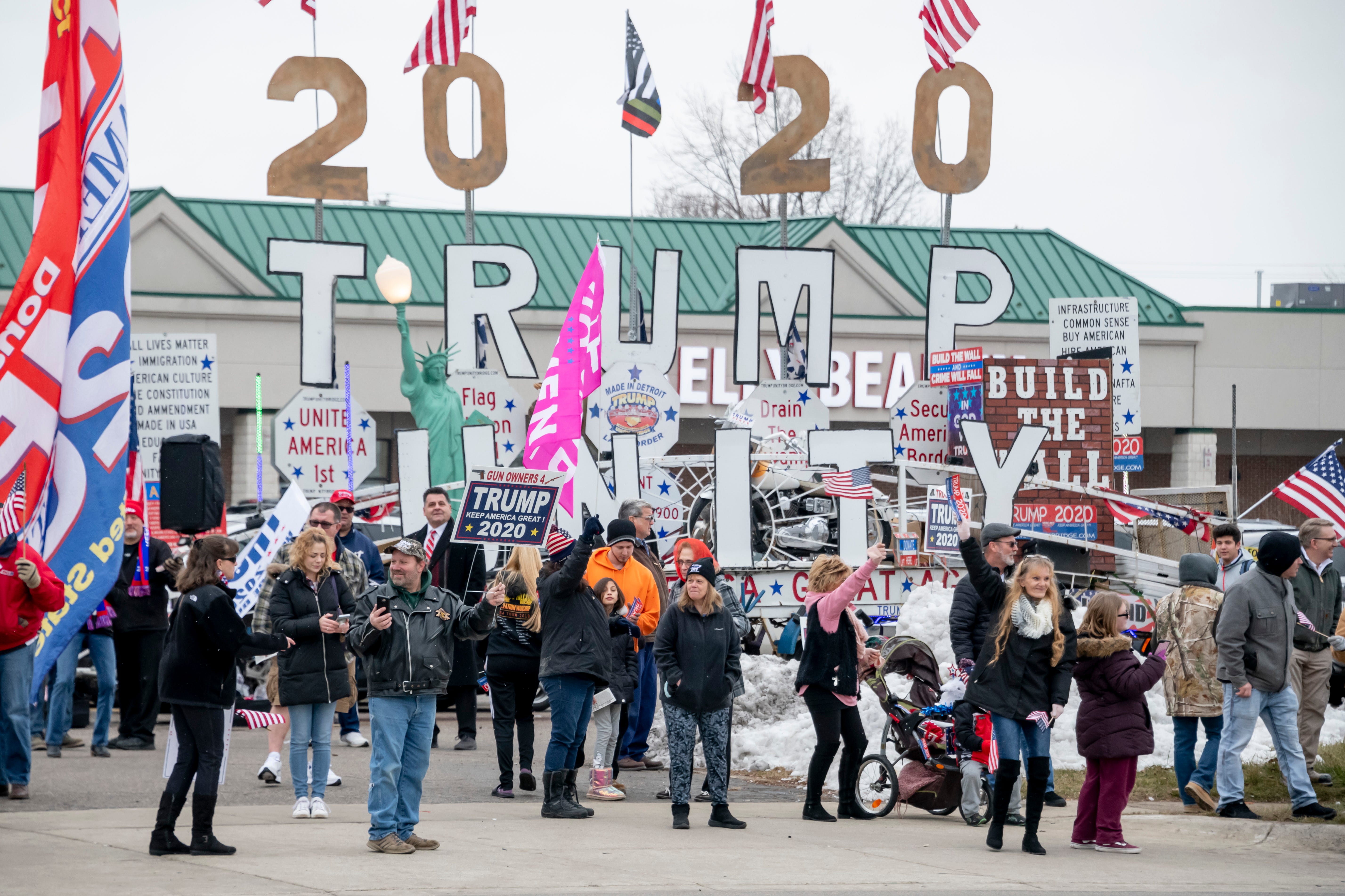 Supporters wave signs and flags while waiting along Van Dyke for the arrival of President Trump.