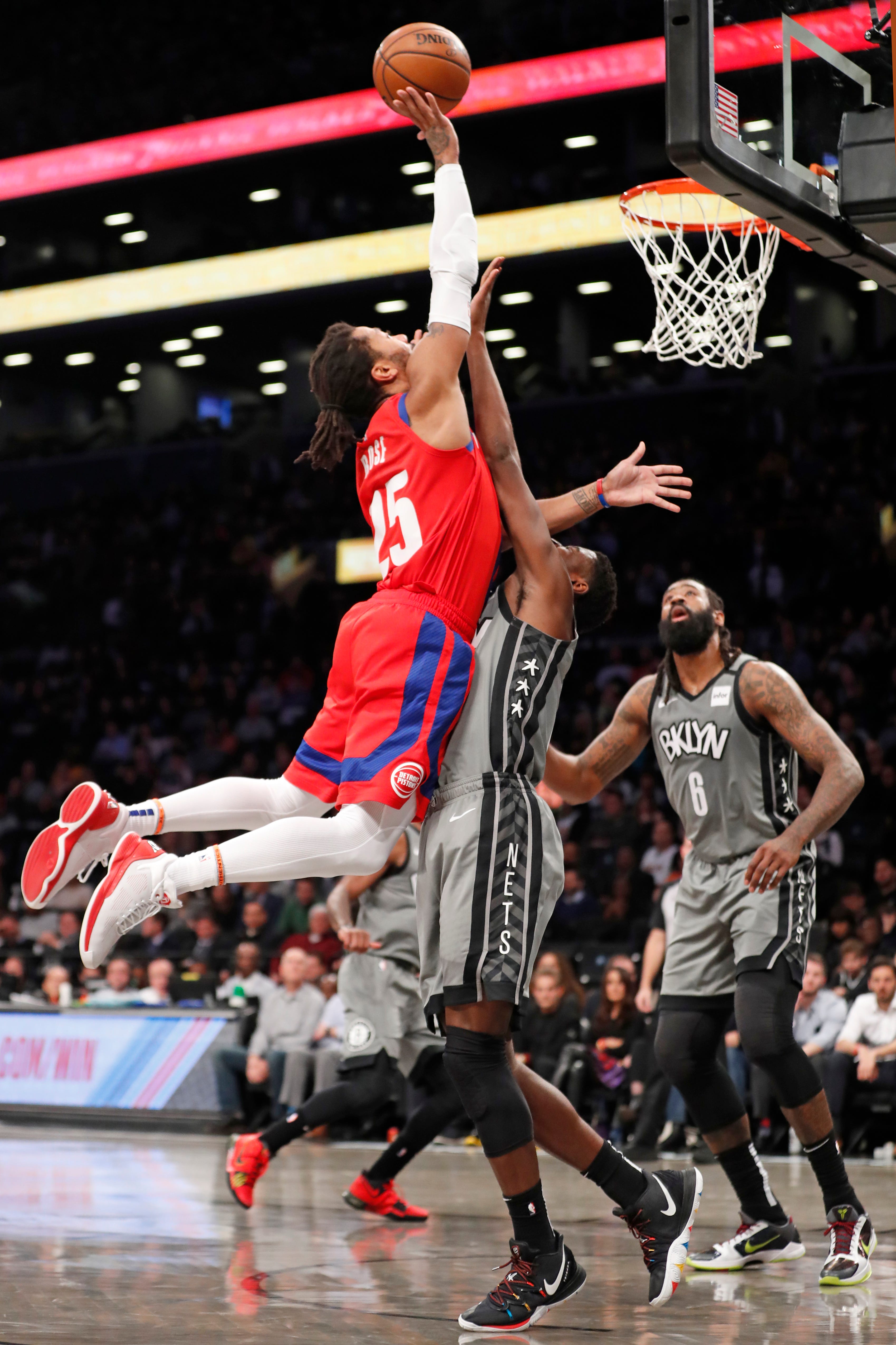 Detroit Pistons guard Derrick Rose goes up for a shot but is fouled by Brooklyn Nets guard Caris LeVert as Nets center DeAndre Jordan watches from the floor during the first half.
