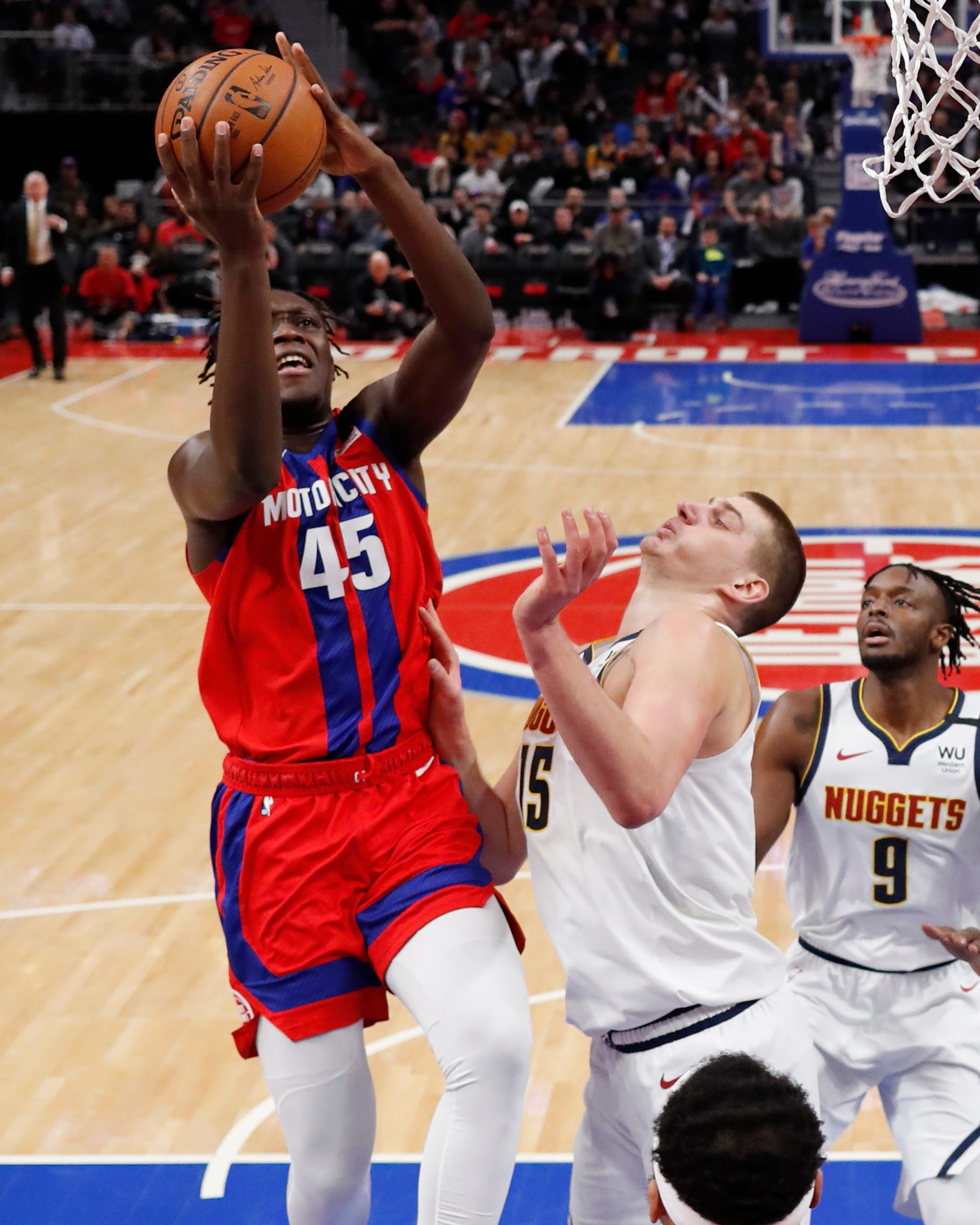 Detroit Pistons forward Sekou Doumbouya (45) attempts a basket as Denver Nuggets center Nikola Jokic (15) defends during the first half.