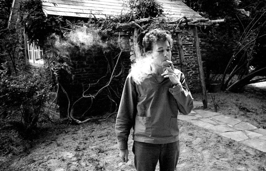 Bob Dylan smoking in the yard at home, Woodstock, NY 1964.
