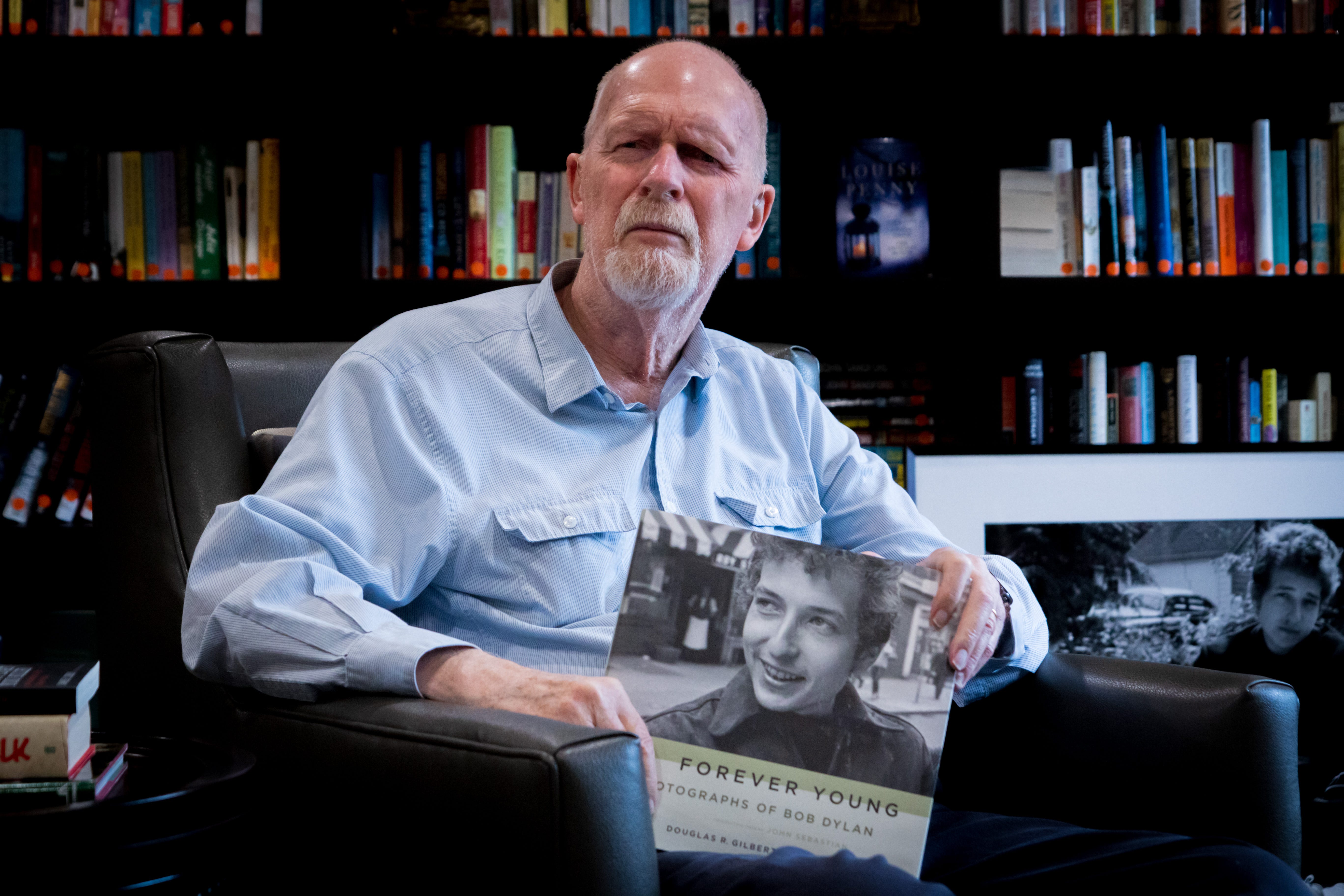 Douglas R. Gilbert holds the book, Forever Young-Photographs of Bob Dylan, which he created with Dave Marsh of Rolling Stone Magazine.