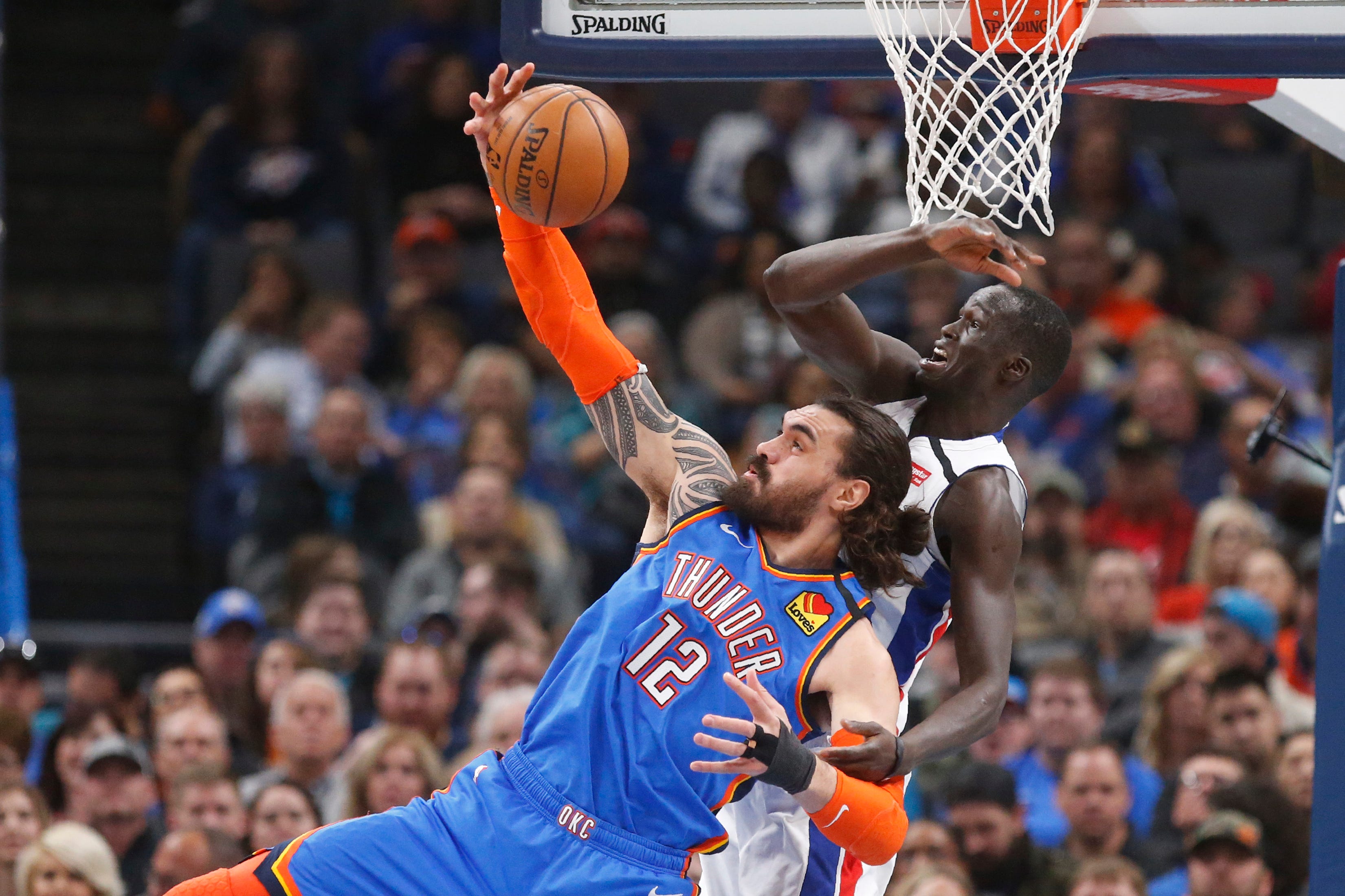 Oklahoma City Thunder center Steven Adams (12) reaches for a pass in front of Detroit Pistons forward Thon Maker, right, during the first half.