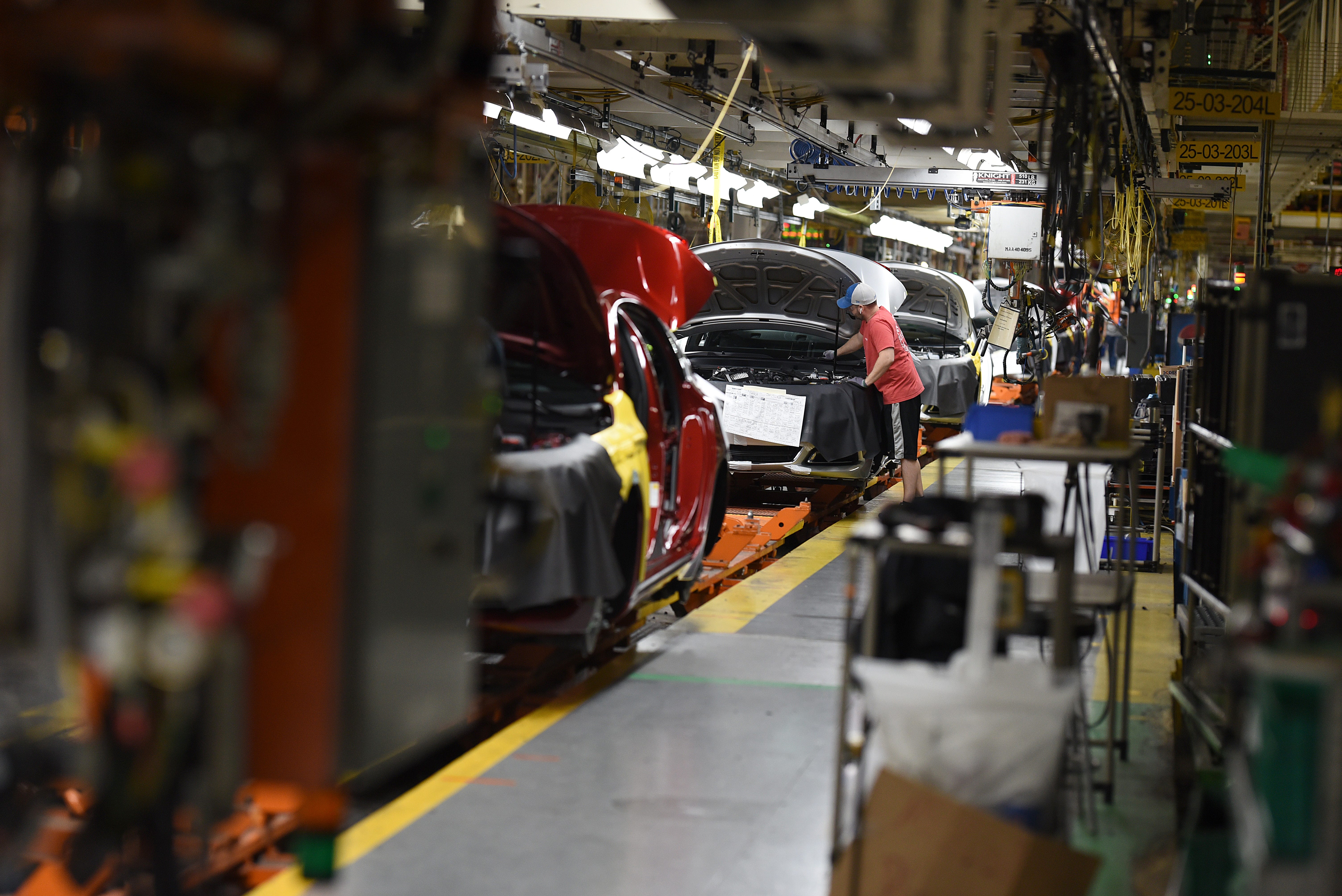 Assembly line workers at the General Motors Detroit-Hamtramck plant work on Chevrolet Impalas.