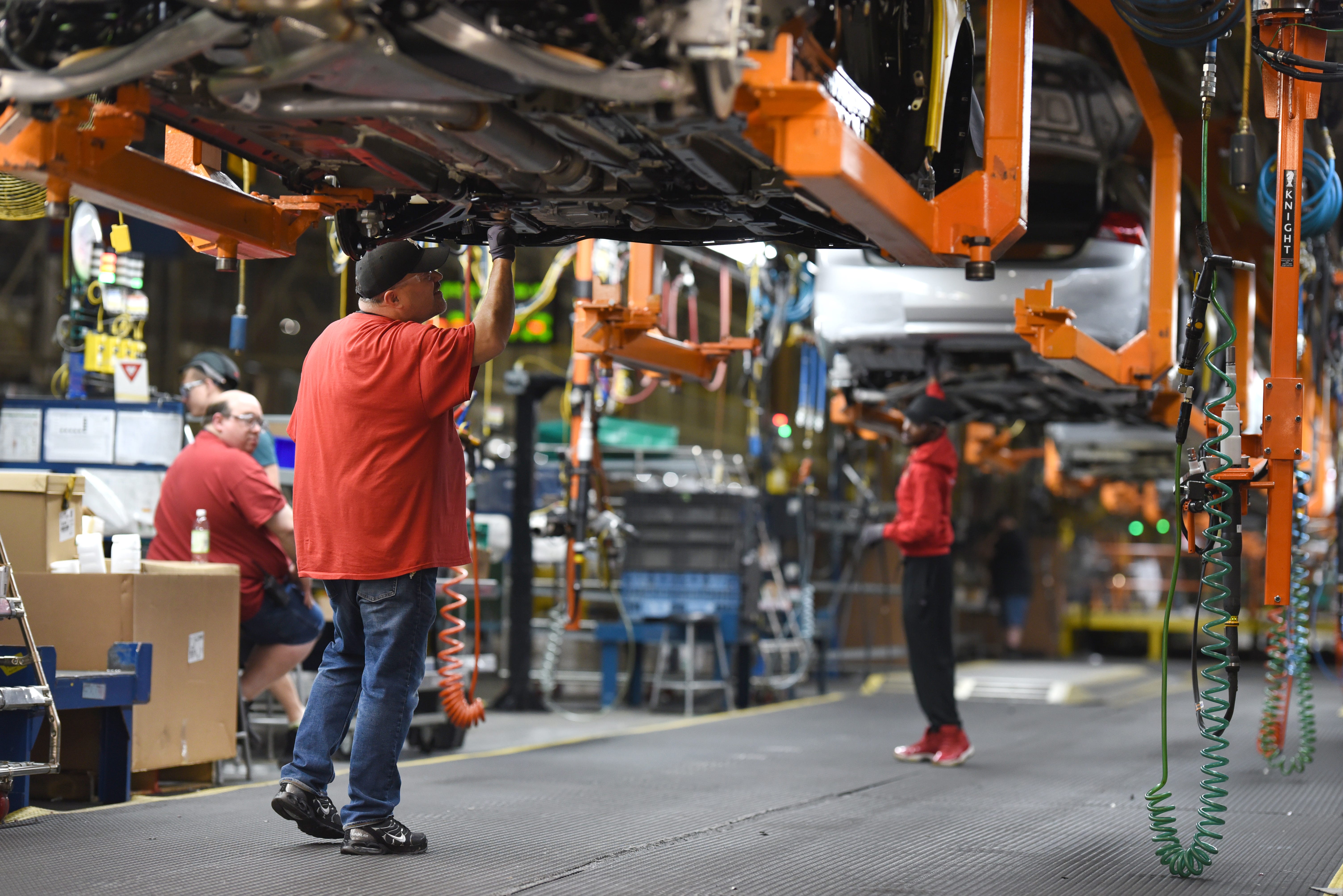 Assembly line workers at the General Motors Detroit-Hamtramck plant work on Chevrolet Impala.