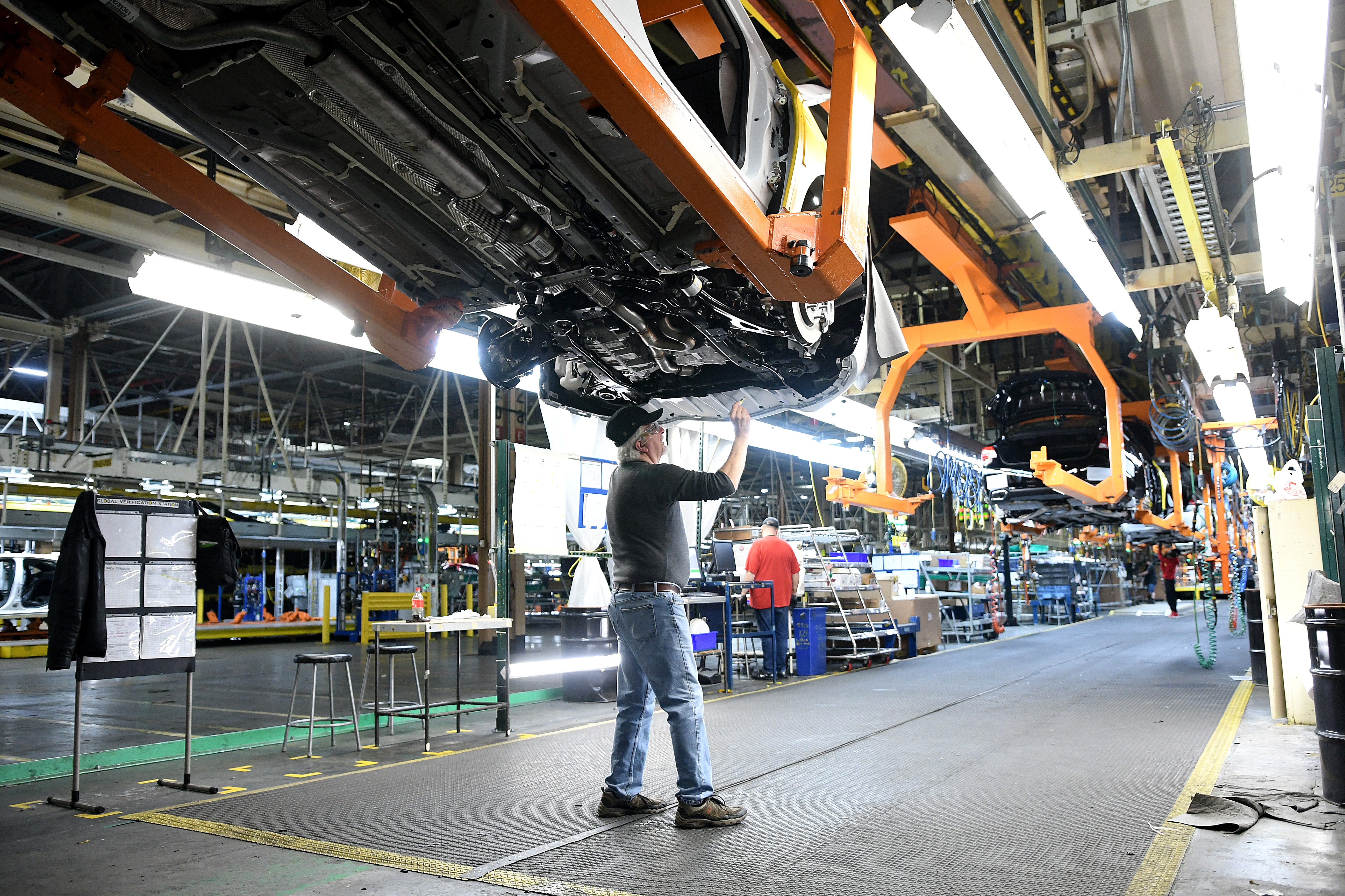Assembly line workers at the General Motors Detroit-Hamtramck plant work on the Chevrolet Impala built at the facility as the plant will be converting from internal-combustion production to EV.