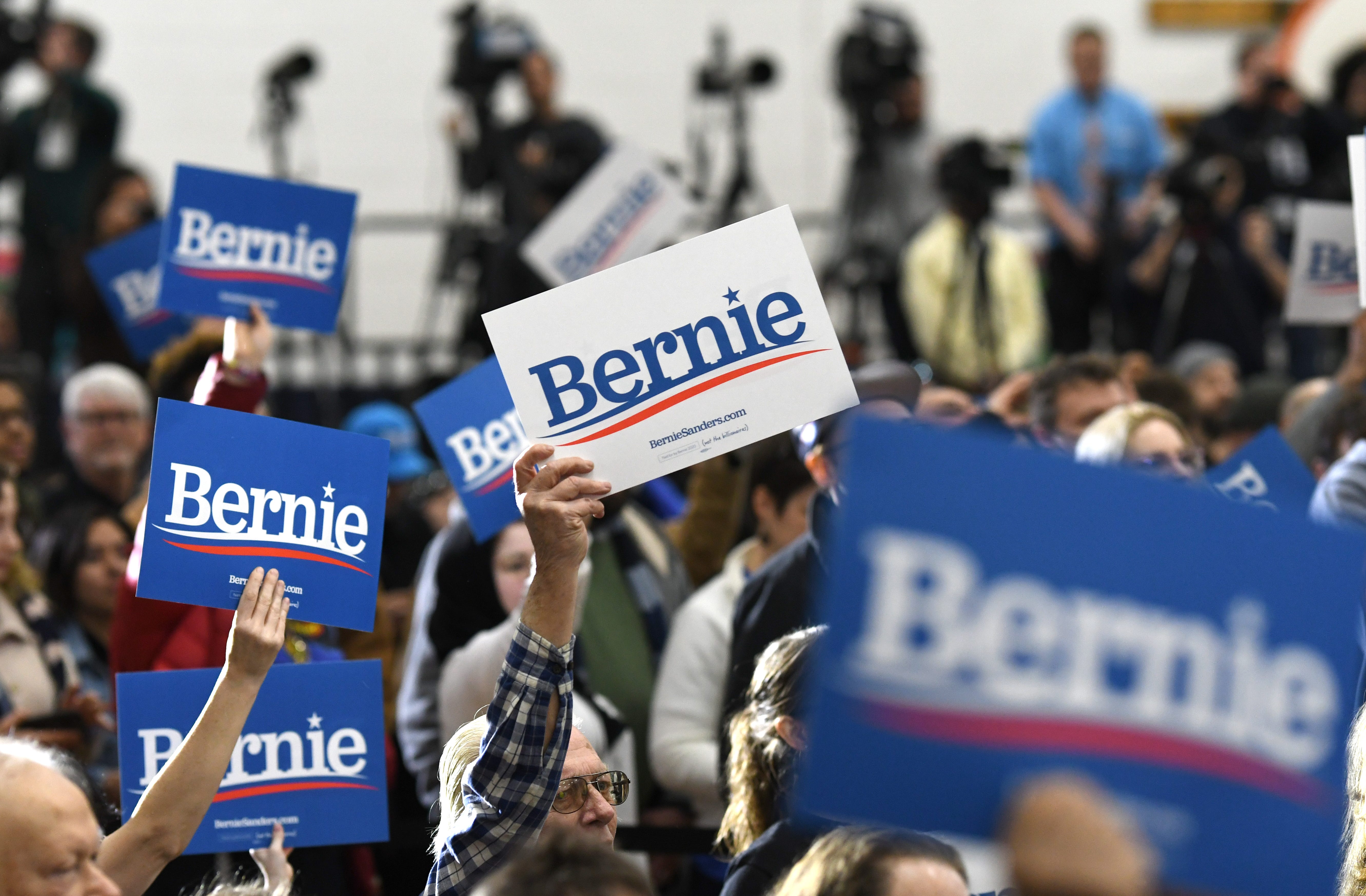 Supporters of Bernie Sanders hold signs during a campaign stop in Dearborn.