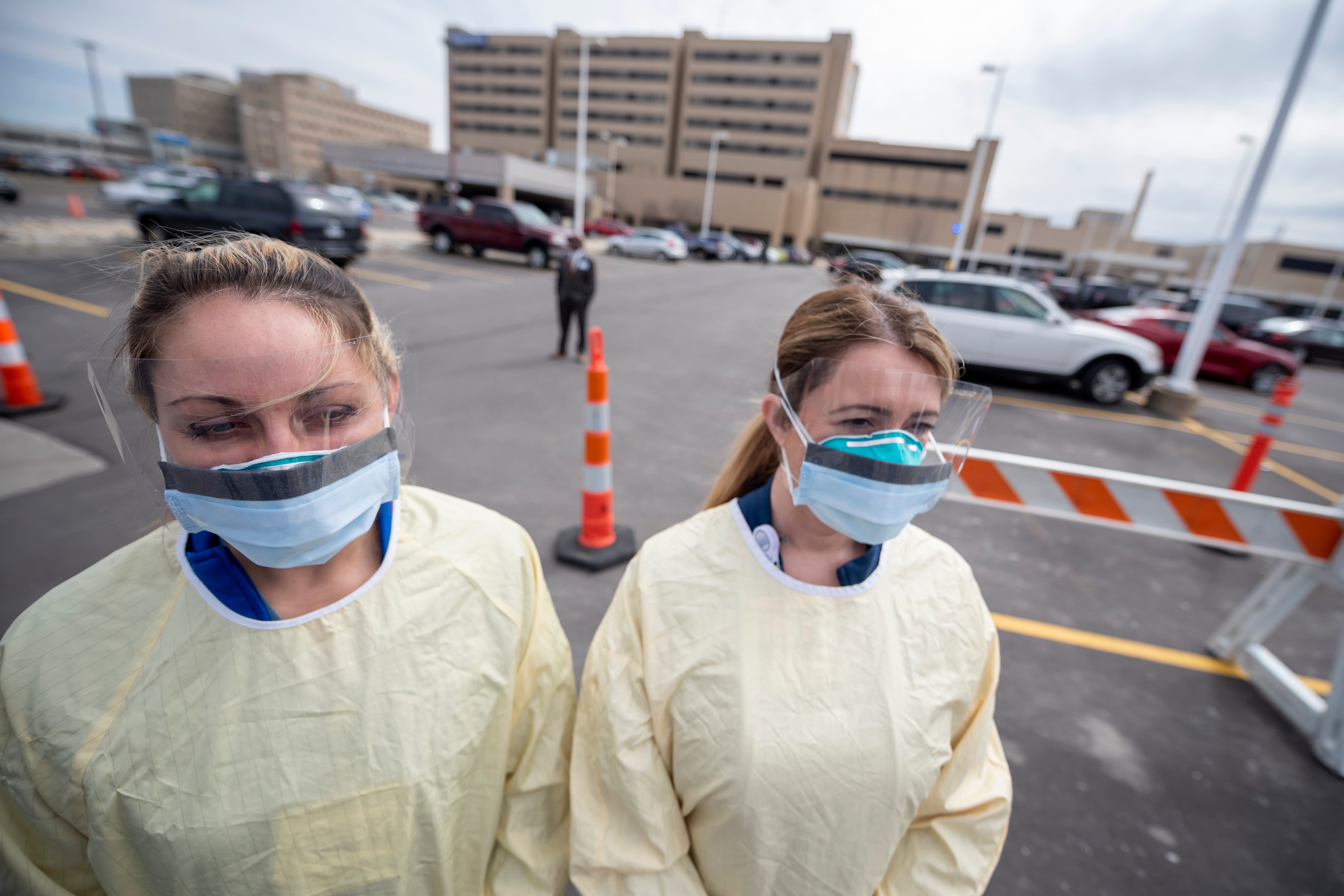 Physician assistant Jessica Hamilton, left, and, registered nurse Amena Beslic, director of the emergency center, stand in front of Beaumont hospital in Royal Oak during a press conference, March 16, 2020. Members of the public concerned that they may be infected with the coronavirus were able to get screening done from their vehicles.