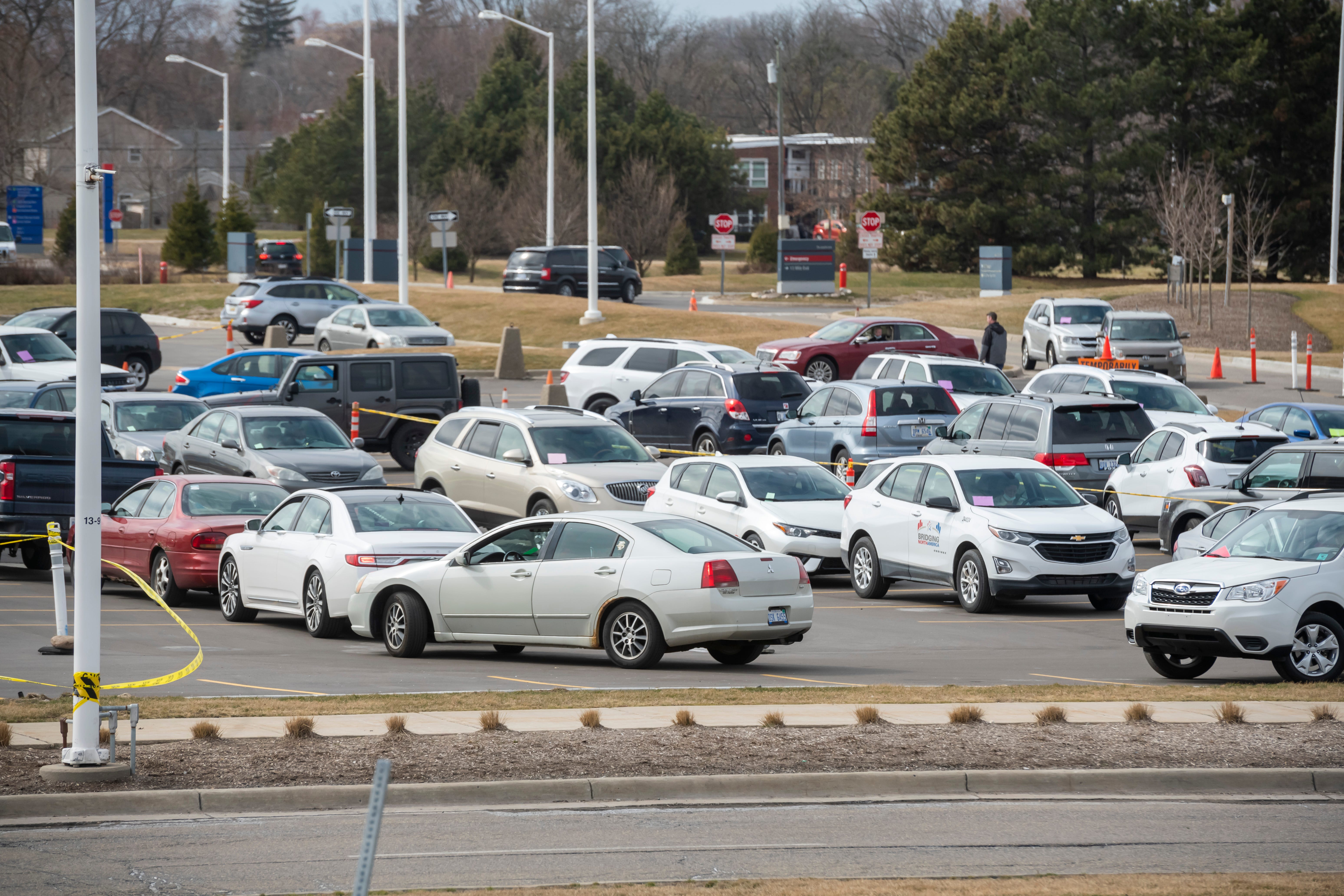 Dozens of cars wait in line to be seen by medical staff during a drive-up screening process at Beaumont hospital in Royal Oak, March 16, 2020. Members of the public concerned that they may be infected with the coronavirus were able to get screening done from their vehicles.