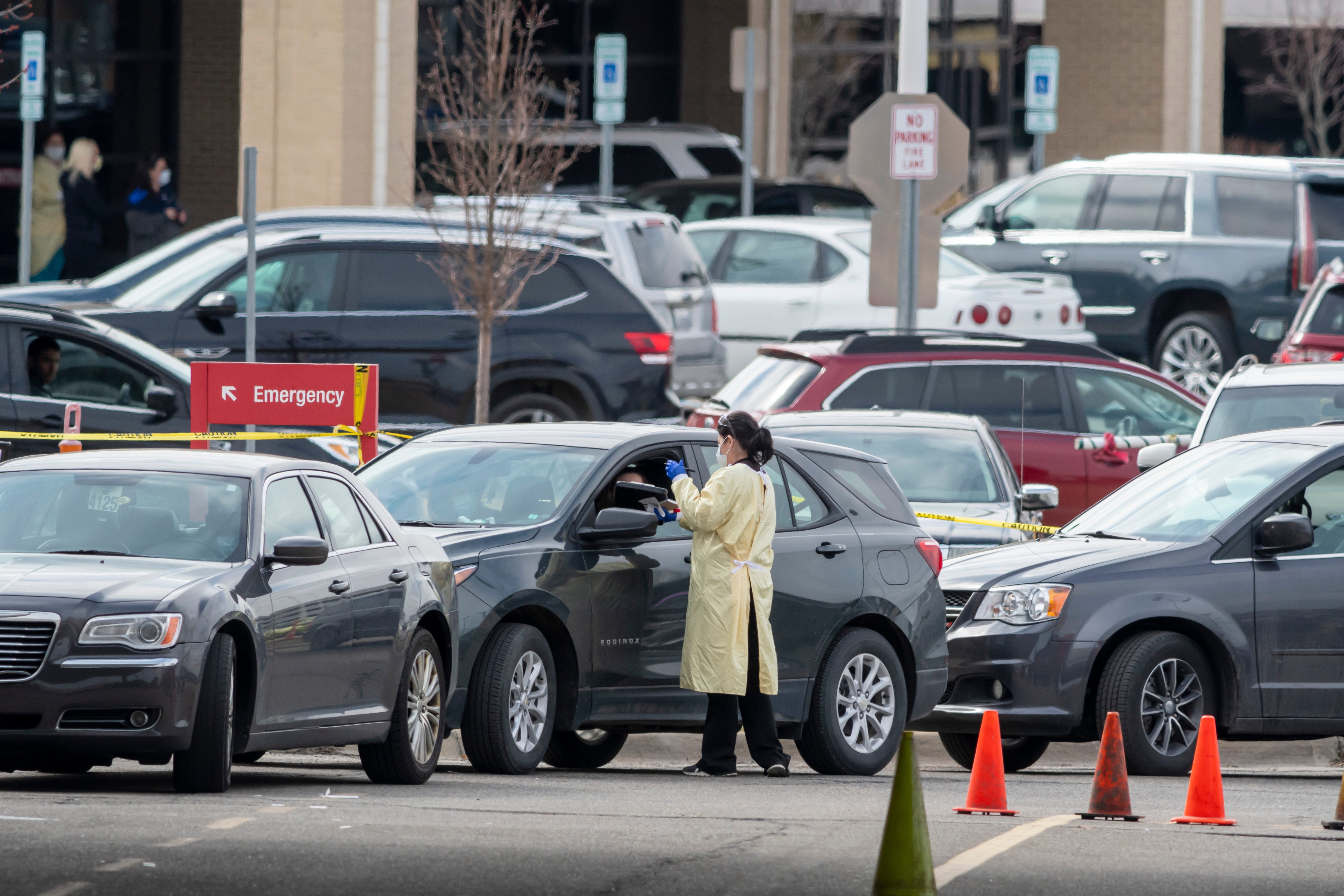 Patients are seen by medical staff during a drive-up screening process at Beaumont hospital in Royal Oak, March 16, 2020. Members of the public concerned that they may be infected with the coronavirus were able to get screening done from their vehicles.