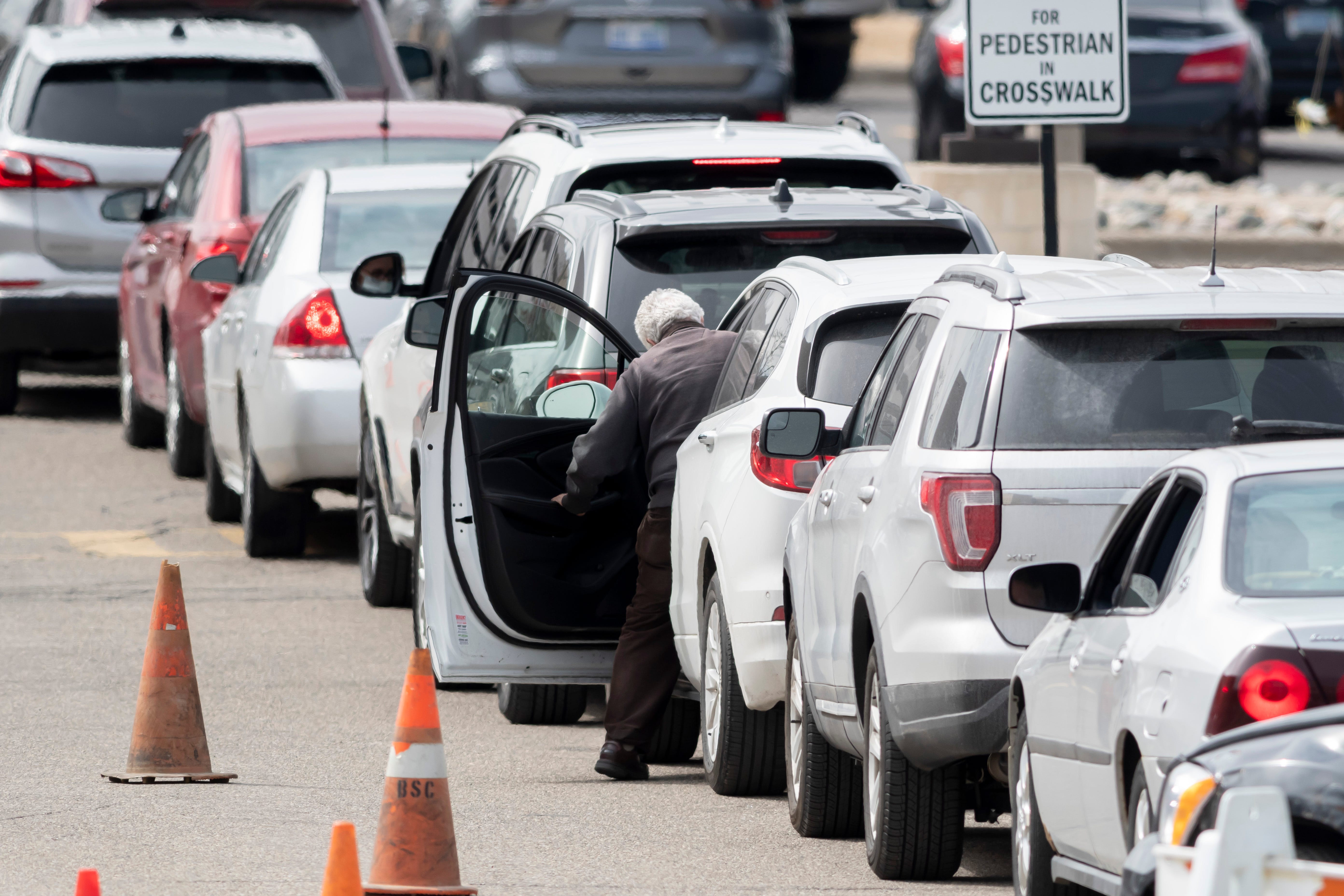Dozens of cars wait in line during a drive-up screening process at Beaumont hospital in Royal Oak, March 16, 2020. Members of the public concerned that they may be infected with the coronavirus were able to get screening done from their vehicles.