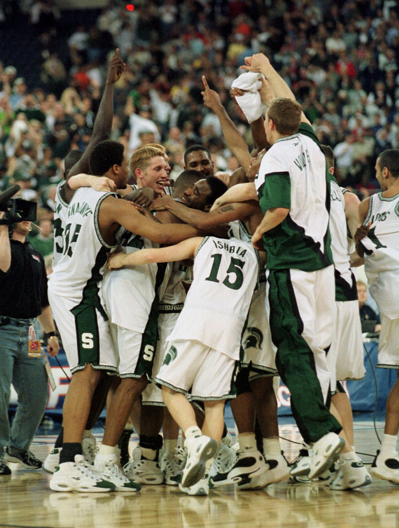 Michigan State ' s Mateen Cleaves is mobbed by his teammates after the Spartans defeated Florida to win the national title.