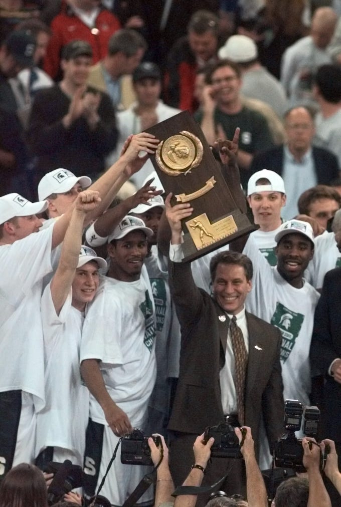 Charlie Bell, left, Tom Izzo, middle, and Mateen Cleaves, right, hold up the national champions trophy in 2000.