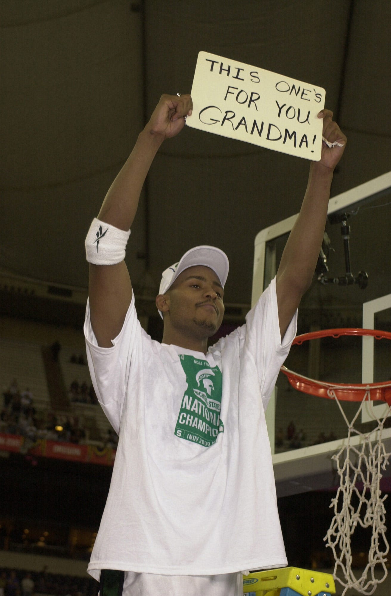 Morris Peterson holds a sign to his grandmother that passed away after Michigan State defeated Florida in the 2000 NCAA finals.