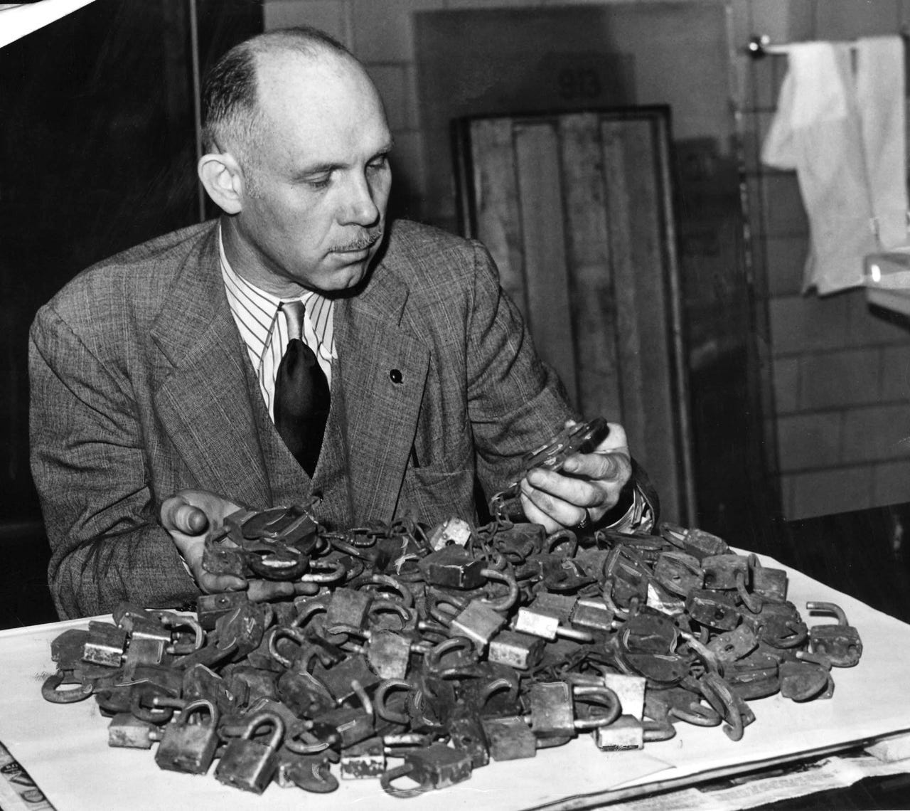 Wilbert C. Garred, assistant custodian of the Federal Building in Detroit, inspects old metal padlocks to be turned in for scrap during the war effort Oct. 6, 1942.