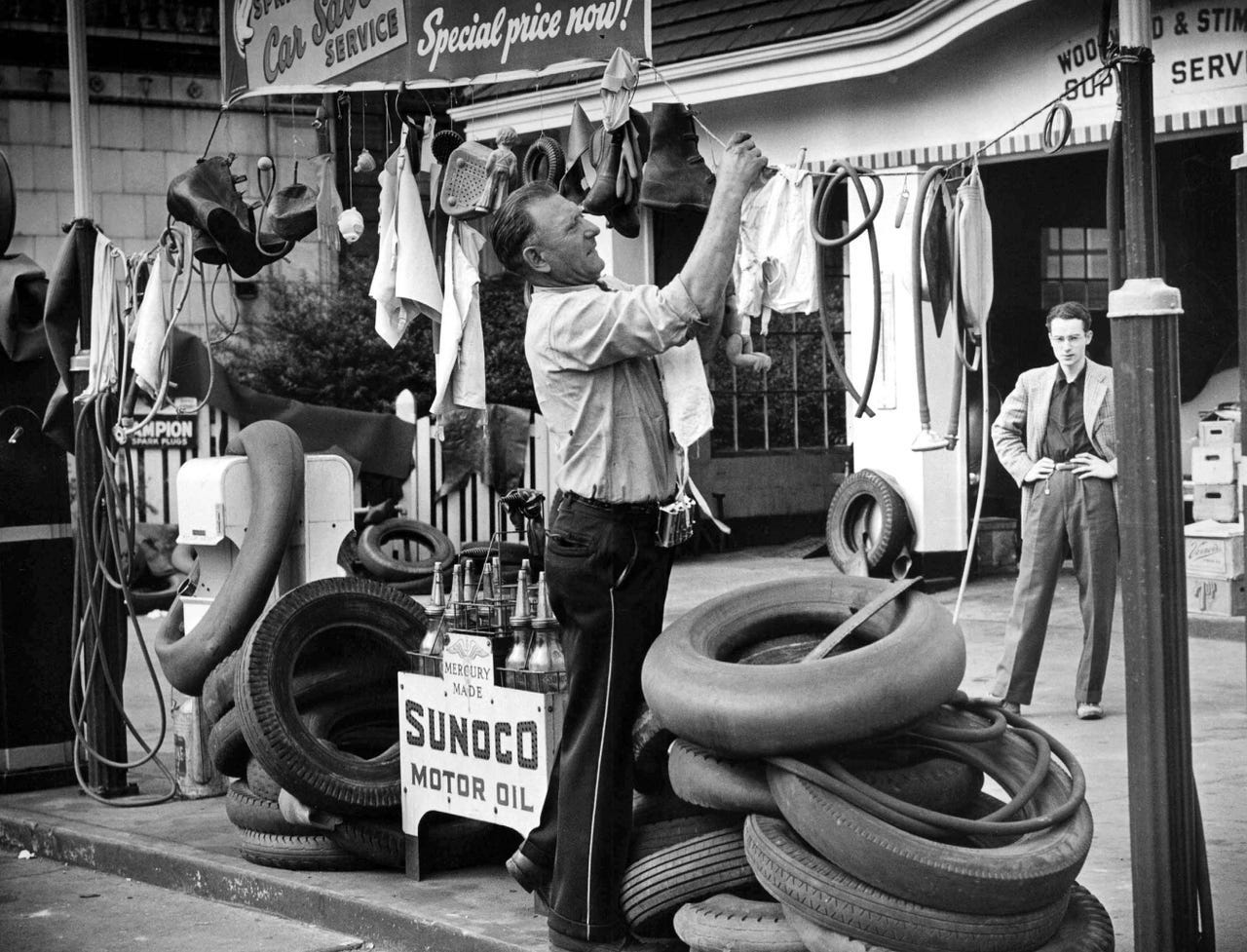 John L. Rancu, an employee at the gas station on Woodward Avenue at Stimson, collects and hangs rubber products to be recycled for the salvage effort during World War II on July 30, 1942.