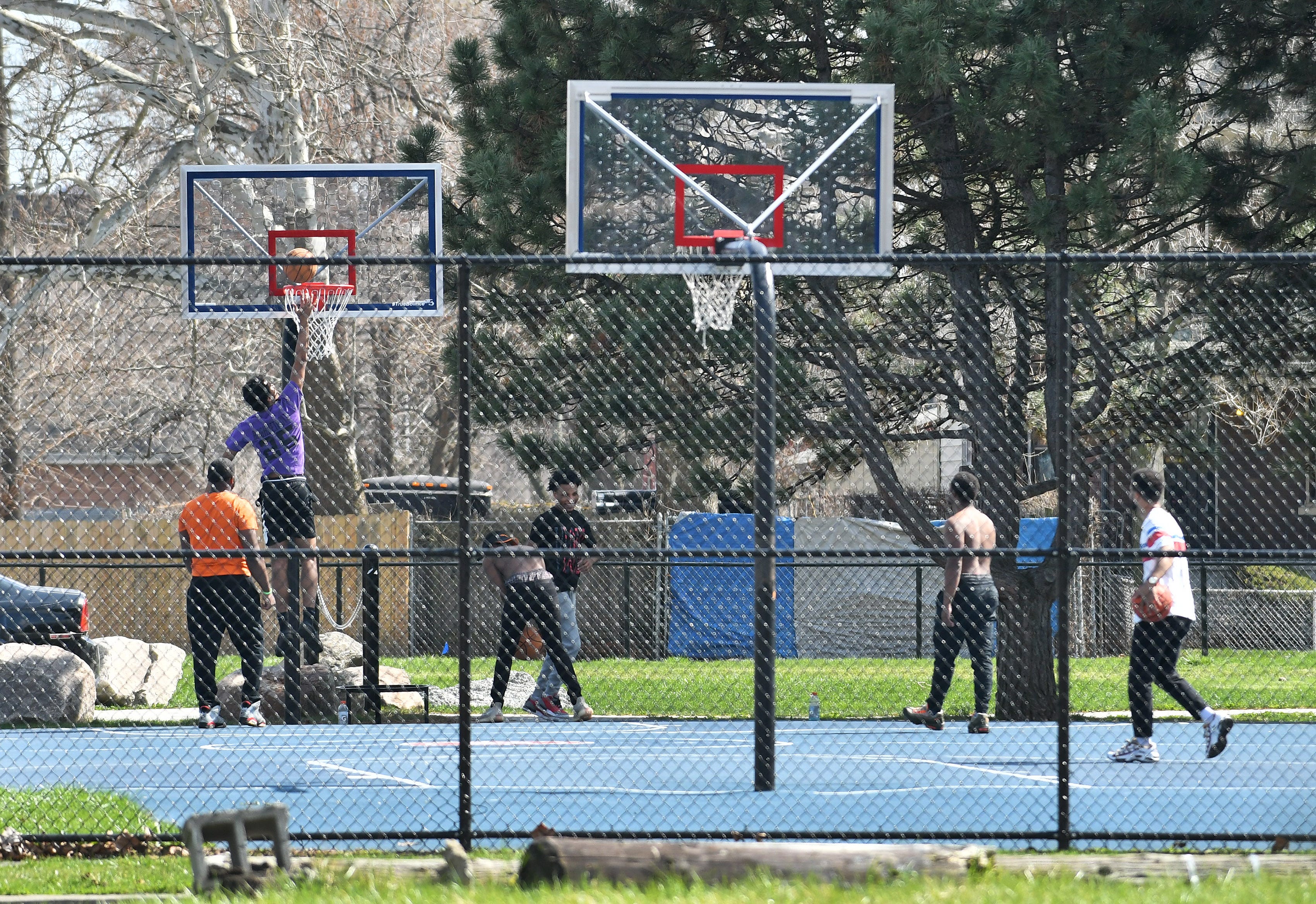 Some young men shoot around on a basketball court at Delores Bennett Park in Detroit on April 8, 2020.