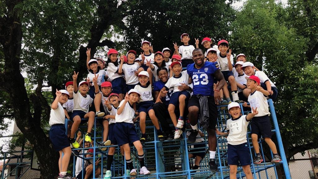 Joshua Cox visits a local school in Osaka with Panasonic Impulse teammates.