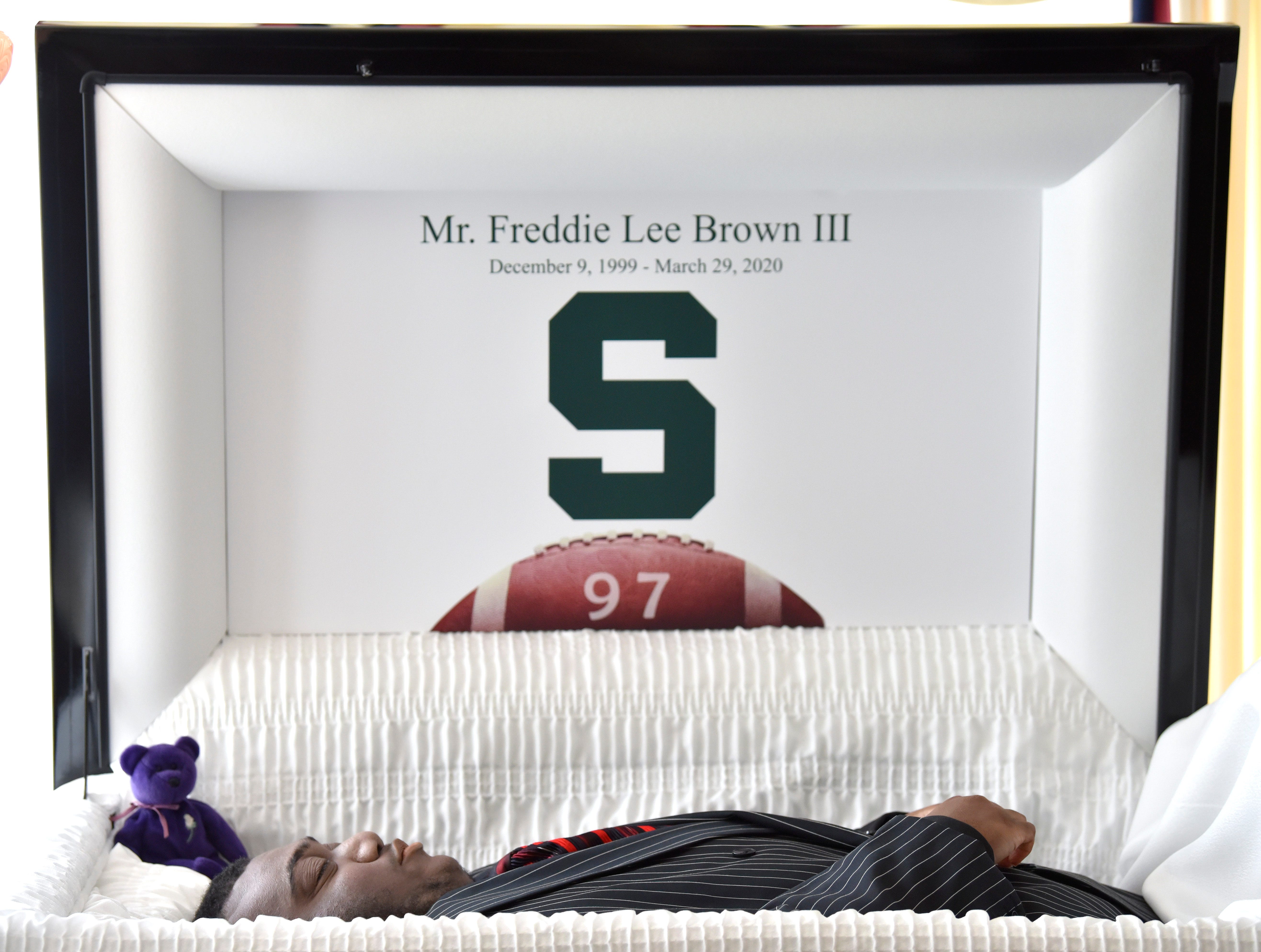 A Michigan State University block " S " and his Grand Blanc High School No. 97 are seen on the casket lid of Freddie Lee Brown III. According to family members, Brown III dreamed of playing football at MSU as a walk-on with hopes of someday playing in the NFL.