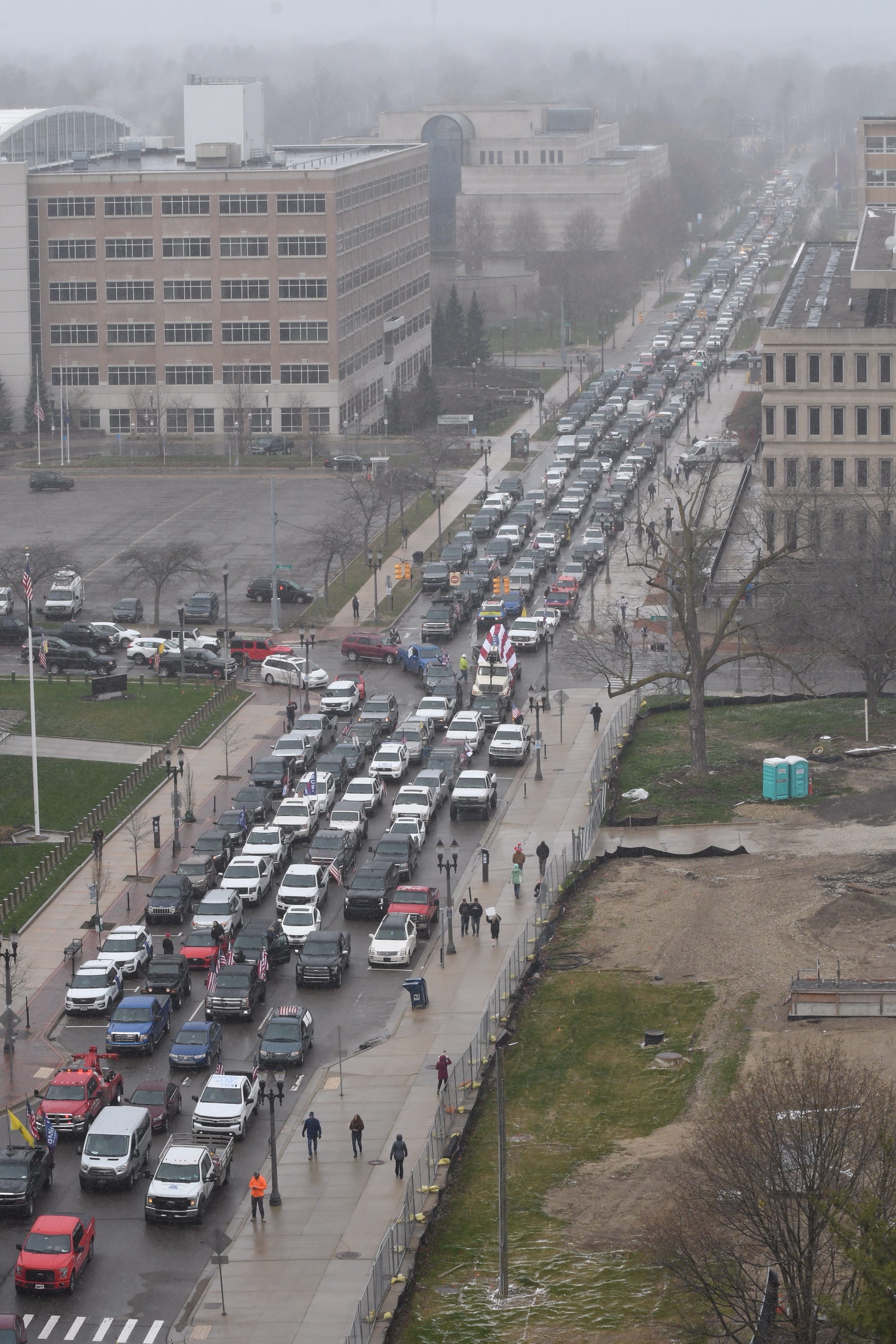 Hundreds of vehicles driven by individuals protesting Gov. Gretchen Whitmer ' s stay-home order jam Allegan Street near the Capitol in Lansing, honking their horns and raising a ruckus before the official protest is even set to begin at noon on Wednesday, April 15, 2020.