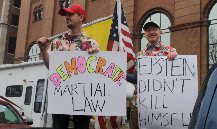 Two protesters participate in a demonstration against Gov. Gretchen  Whitmer's stay-at-home order on Wednesday, April 15, 2020. One holds a sign that says, "Epstein didn't kill himself."