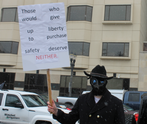 An unnamed protester holds a sign during a demonstration against Gov. Gretchen Whitmer's stay-at-home order on Wednesday, April 15, 2020.