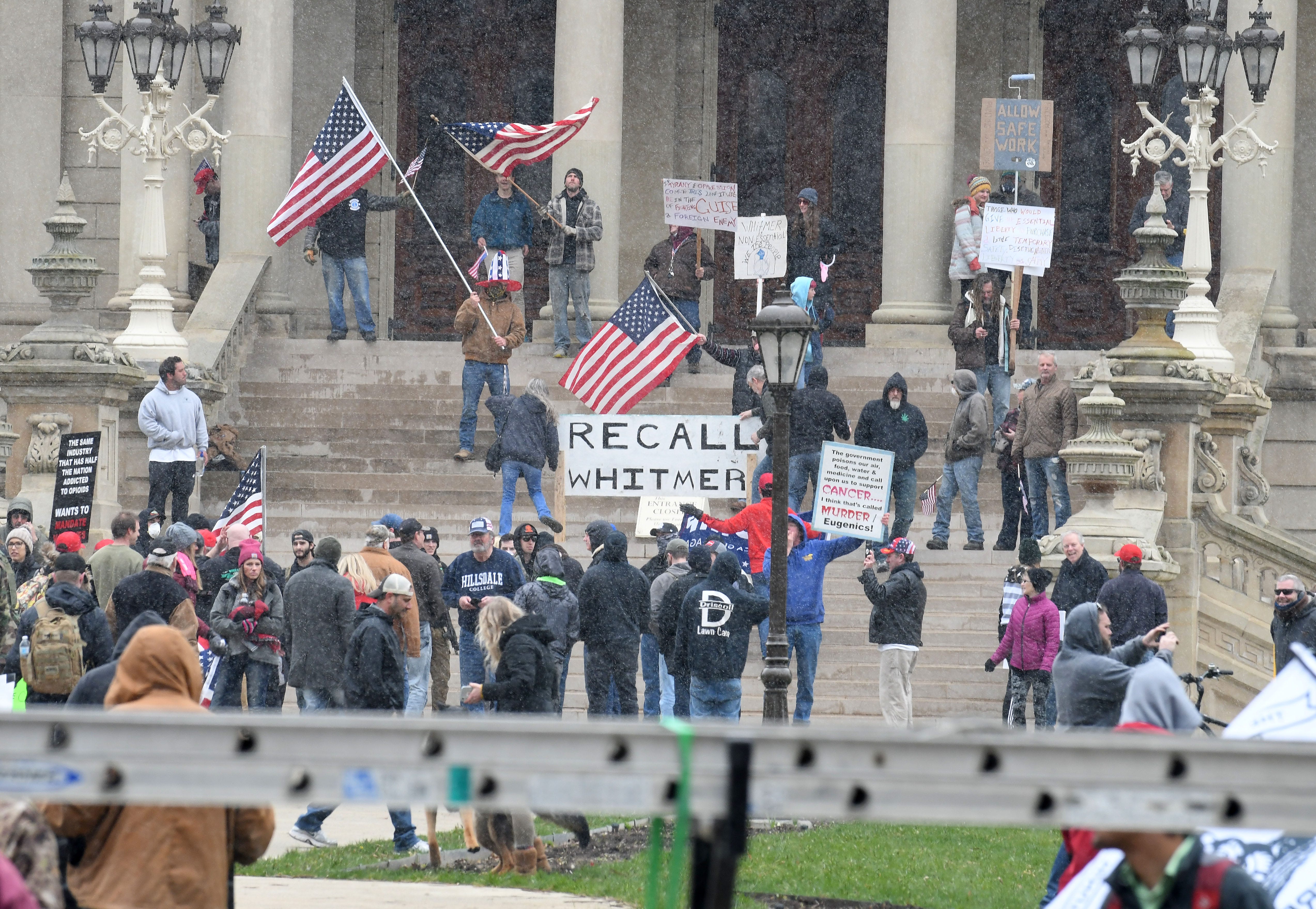 A group of people on the steps of the Capitol protest some of Gov. Gretchen Whitmer ' s new executive orders Wednesday.