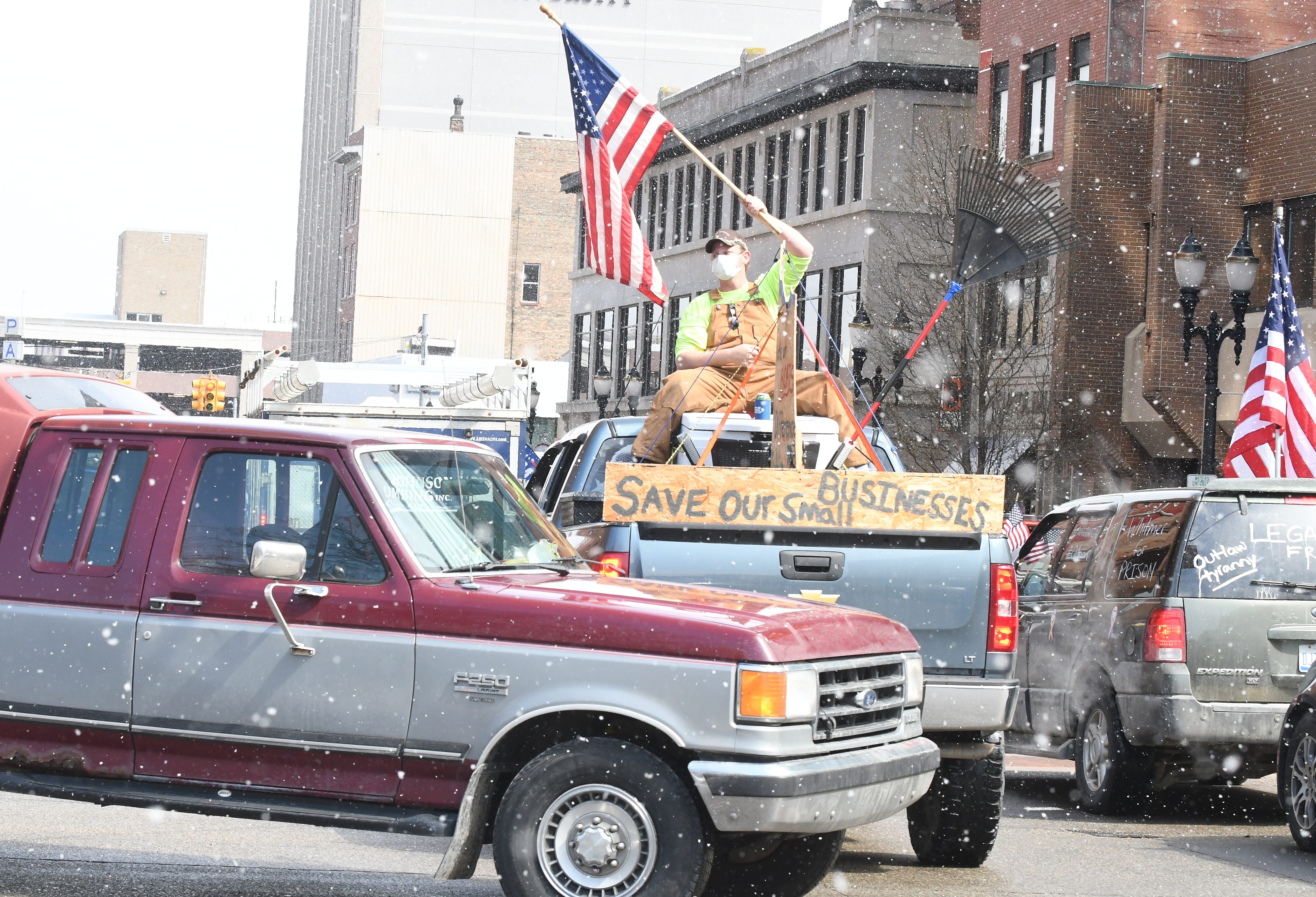 Protestors, from their cars and on foot, surround the State Capitol during "Operation Gridlock" in Lansing, Michigan on April 15, 2020.