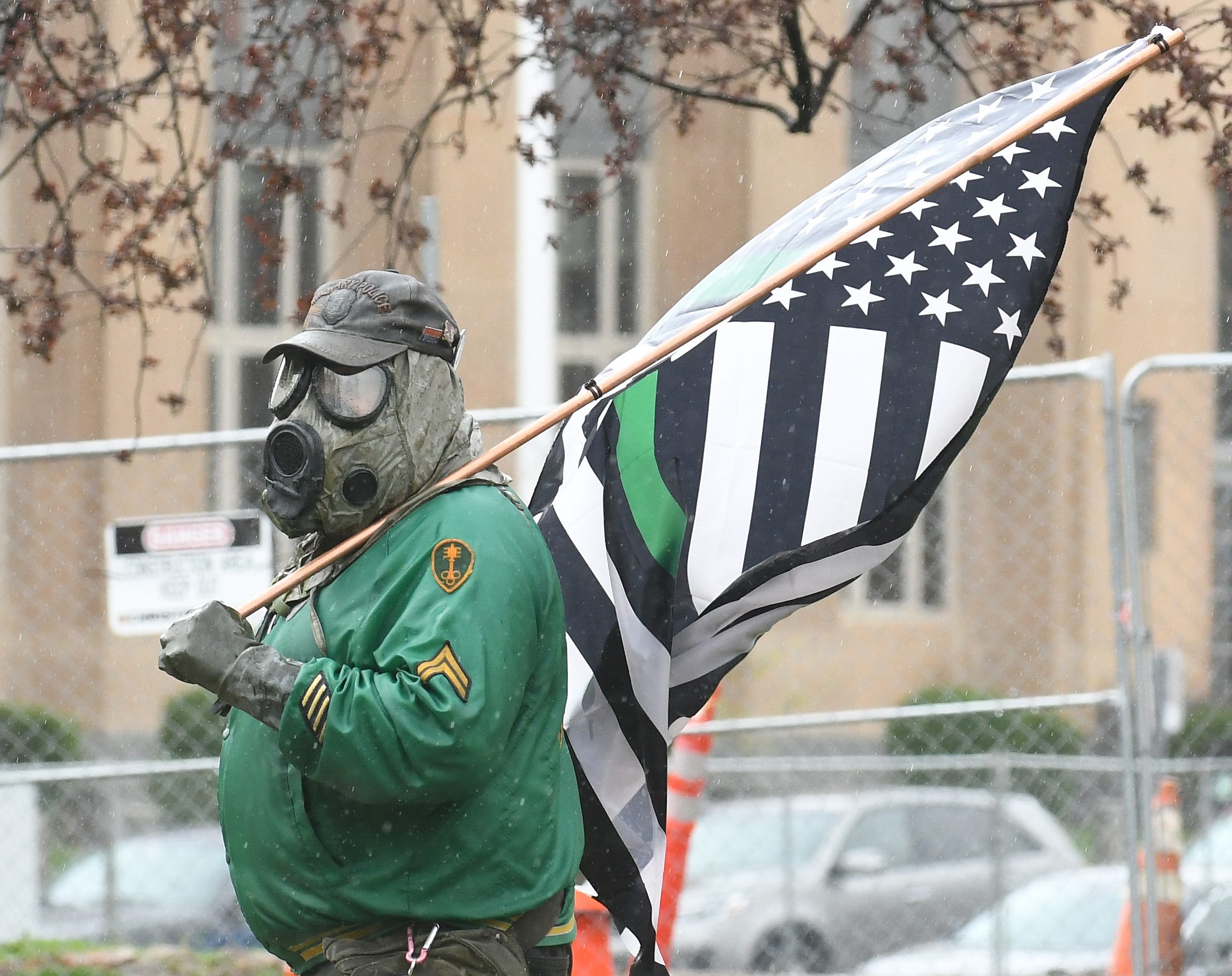 A masked protester during the " American Patriot Rally, " in protest of Gov, Gretchen Whitmer ' s coronavirus pandemic policies, near the Michigan Capitol in Lansing on April 30, 2020.