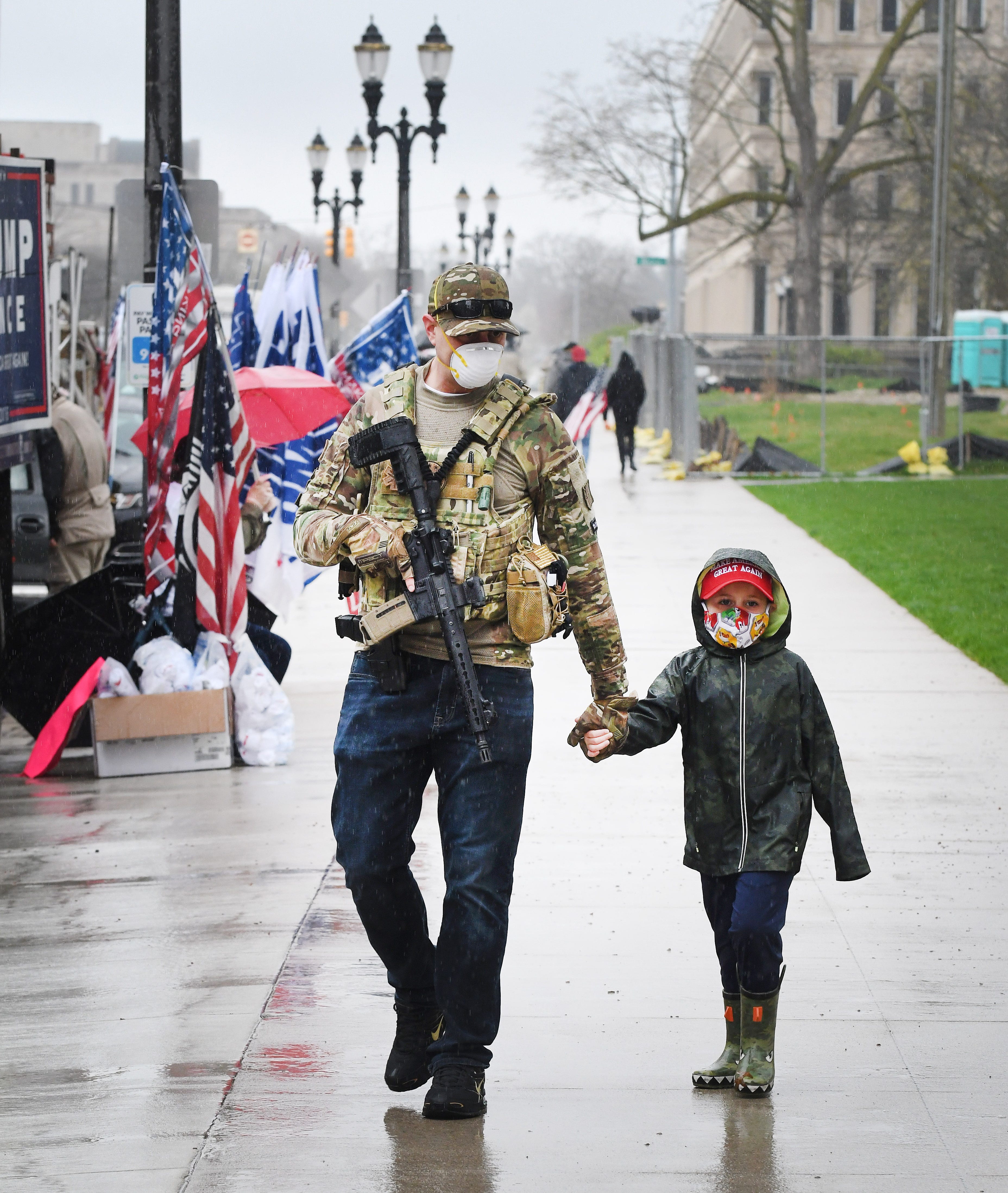 Lee Miller with son Christian Miller, 5, walk the sidewalk around the Michigan Capitol during the " American Patriot Rally.