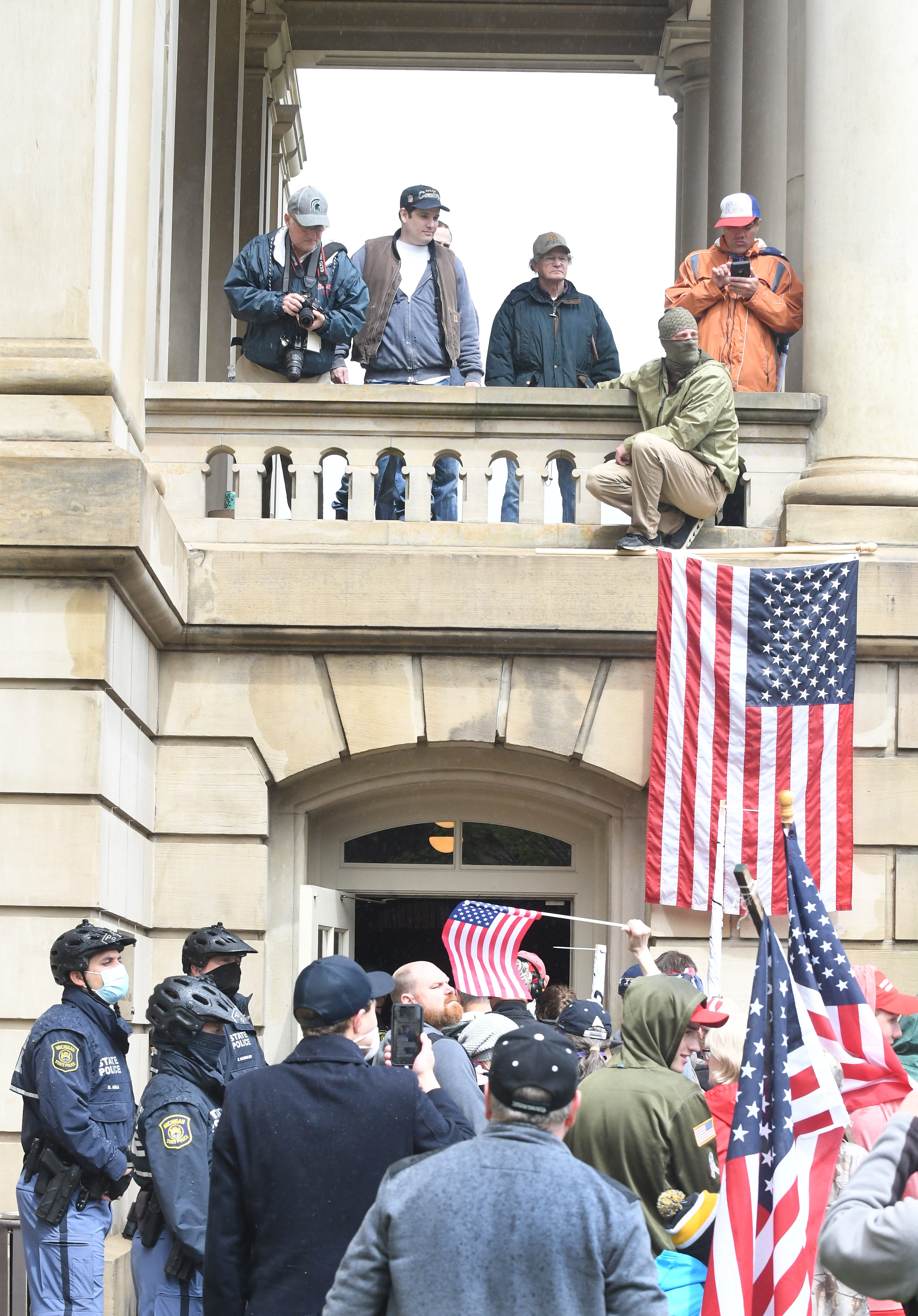 Protesters wait in line to go into the Capitol after the " American Patriot Rally " in Lansing on April 30, 2020.