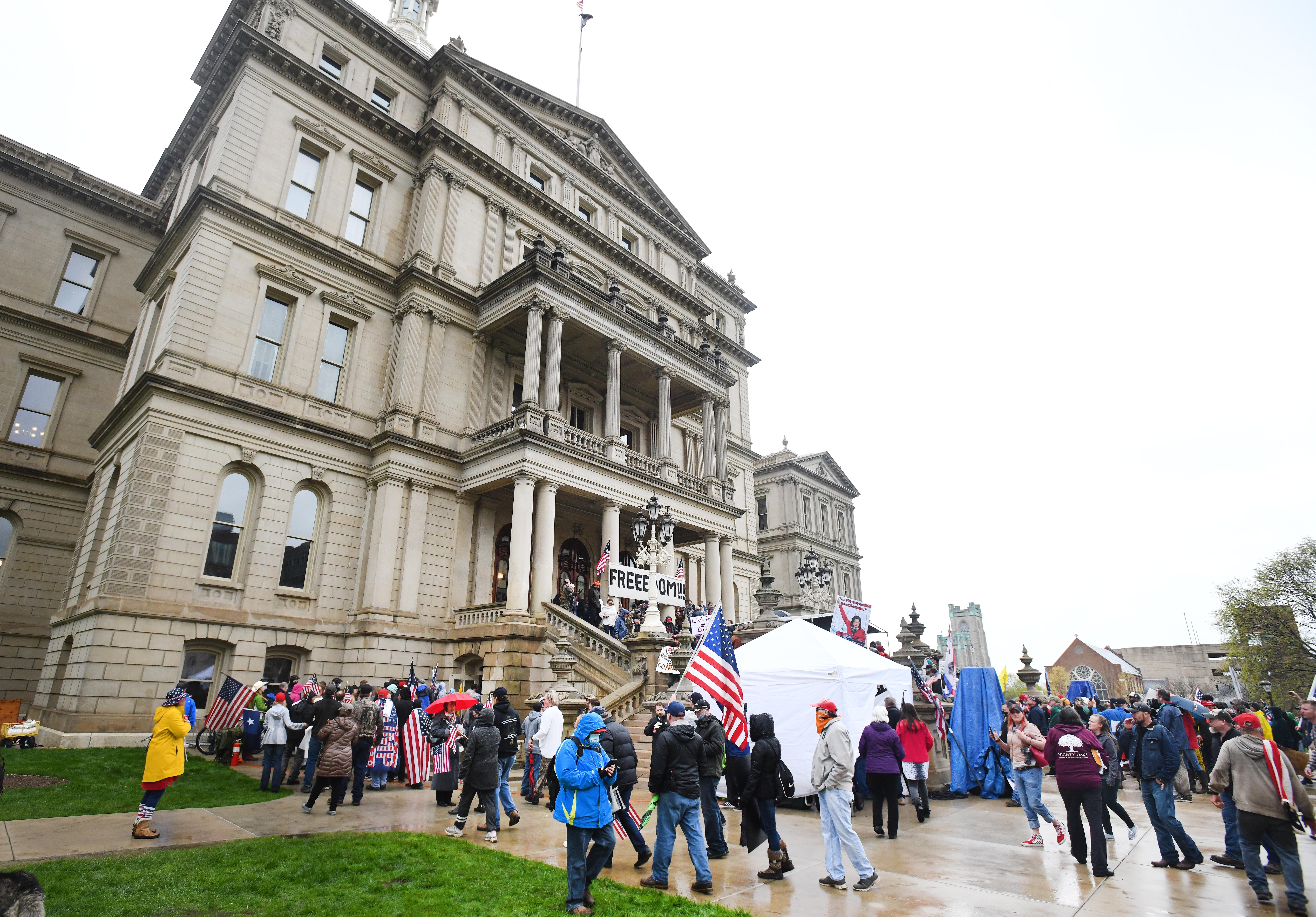 Protesters wait in line to go into the Michigan Capitol after a rally on the front stemps and lawn in Lansing.