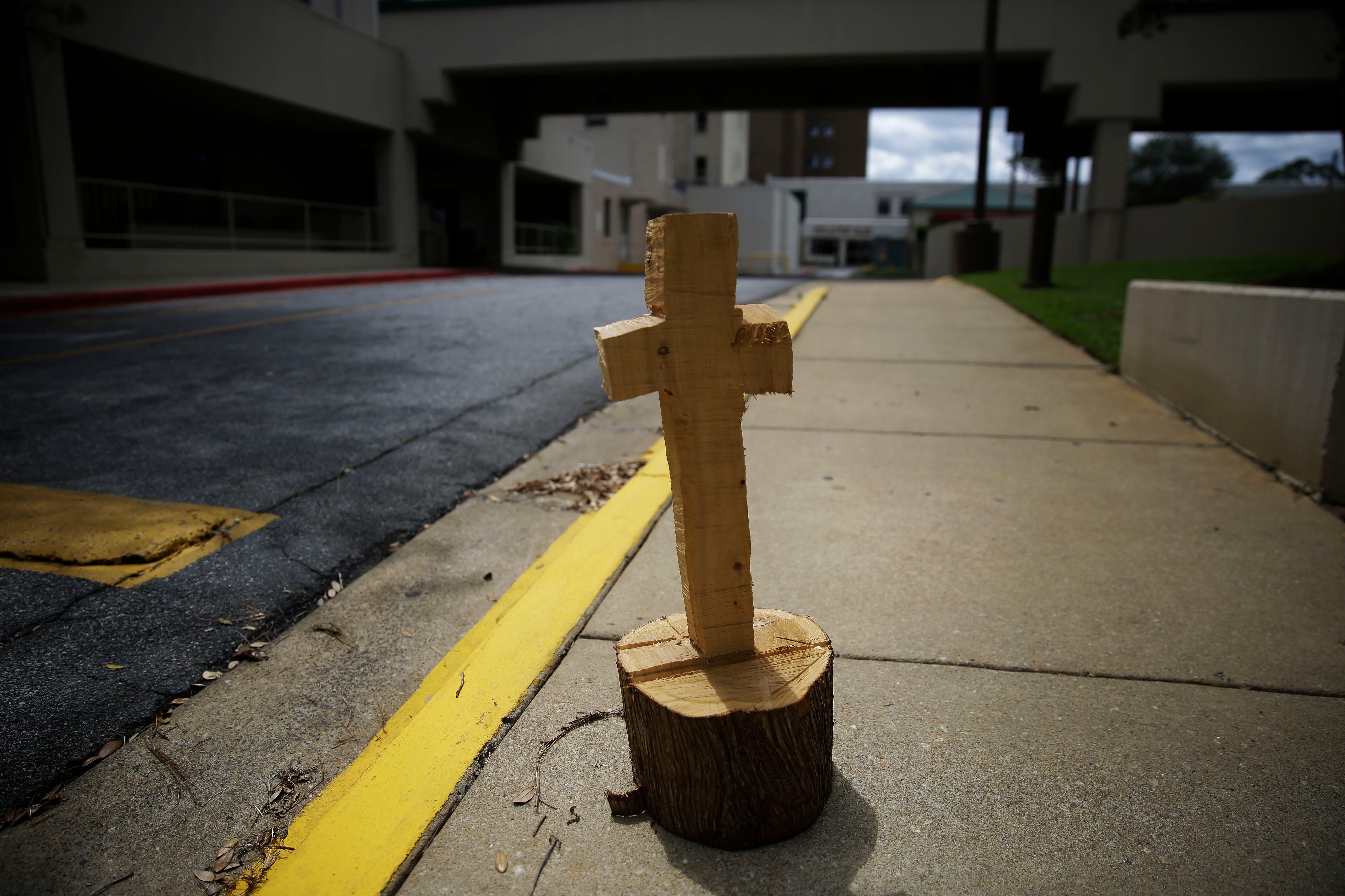 A wooden cross made from a tree stump, known by some locals as a symbol of hope, sits outside of Phoebe Putney Memorial hospital on Monday, April 20, 2020, in Albany, Ga. The patients were very sick. Some died within hours. Some died on the way, in the back of ambulances. The region is predominantly black, but even so, African Americans died disproportionally, said Phoebe Putney Memorial's chief executive officer Scott Steiner. In the 10 counties in the cluster hit hard by coronavirus, the population is 55 percent black. But African Americans account for about 80 percent the deaths at the hospital.