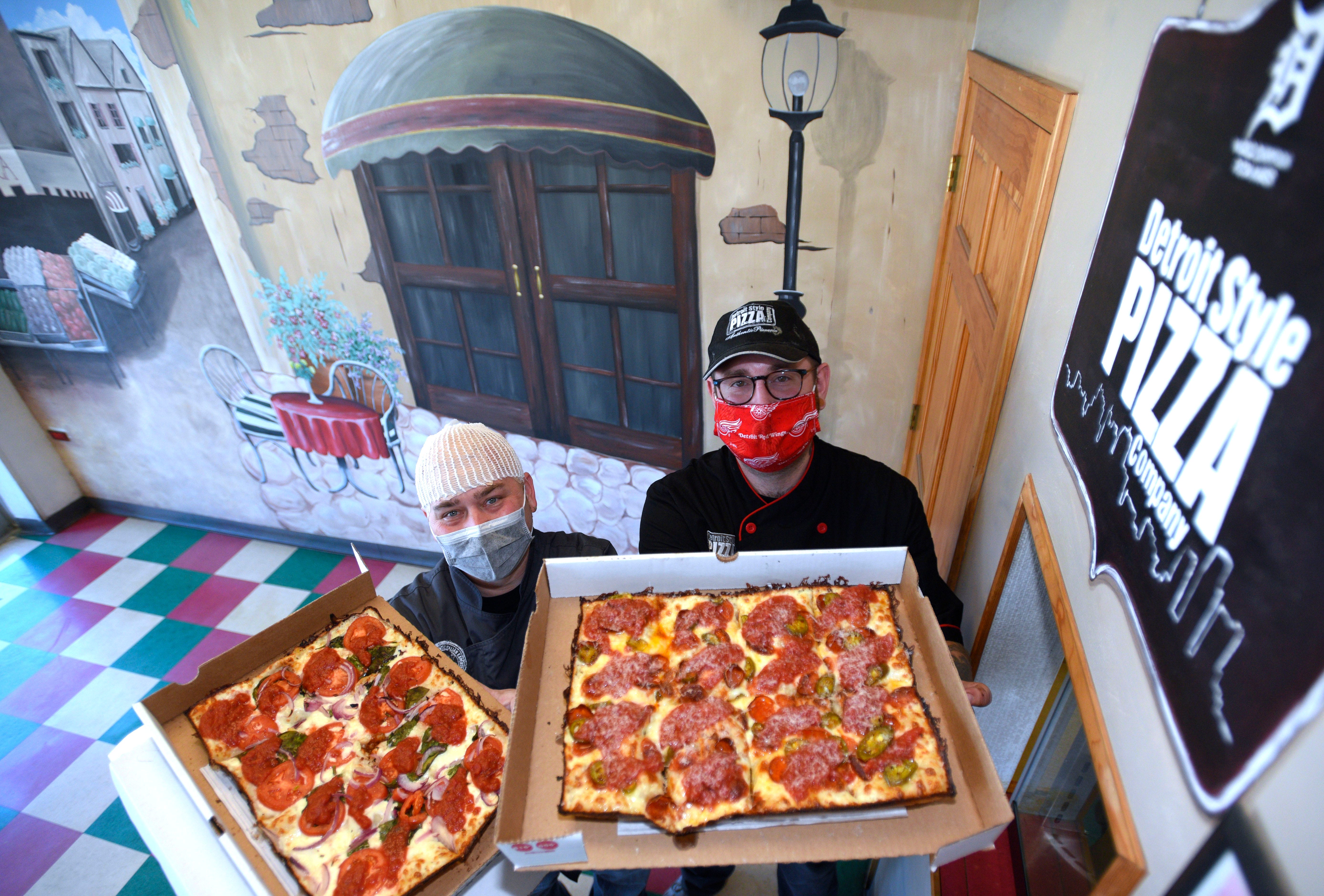 Detroit Style Pizza Company co-owners Shawn Randazzo, left, and Joe Maino pose with the Margherita In The D Pizza and the Harper Hornet pizza, respectively.
