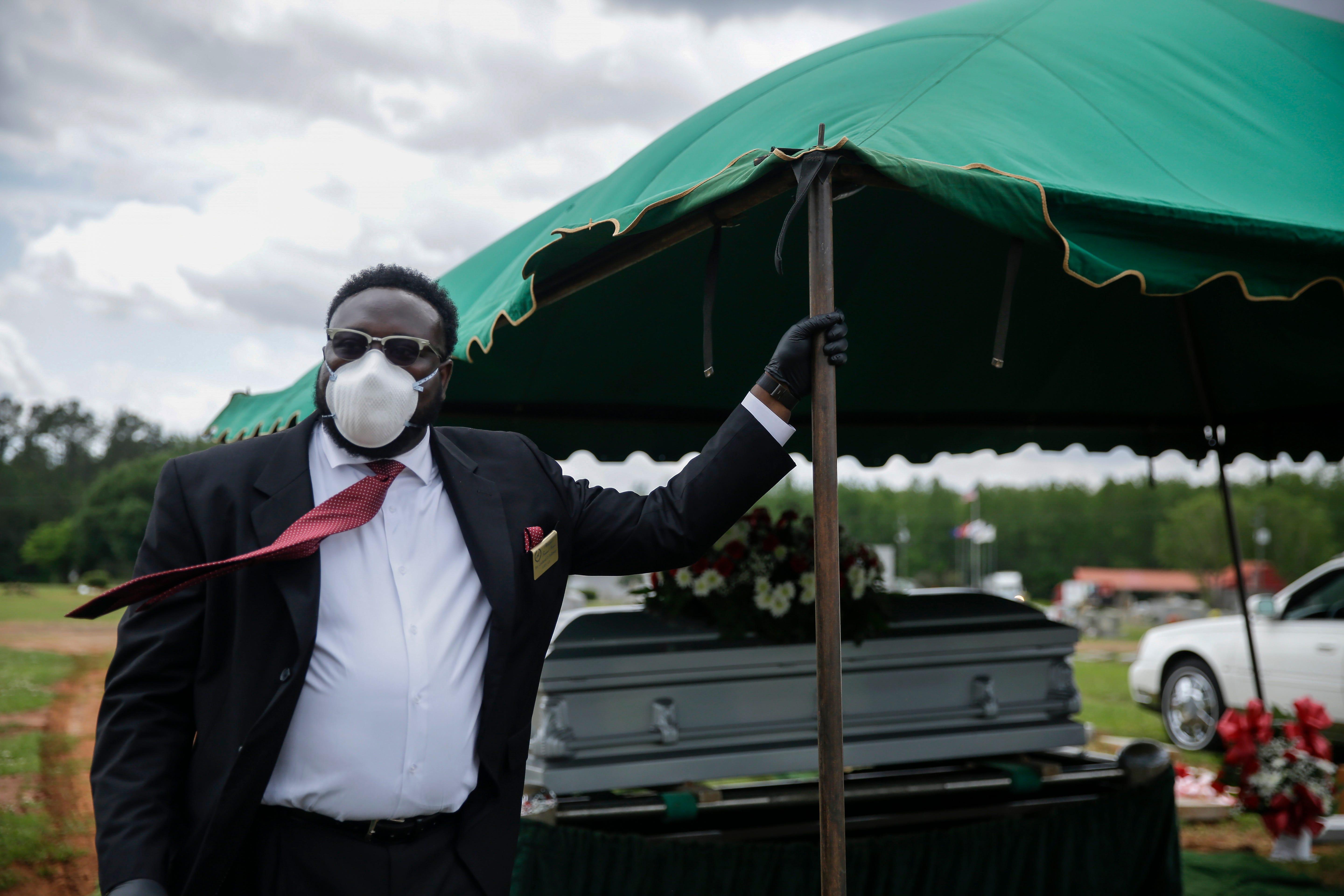 Cordarial O. Holloway wears a protective mask as his tie blows in the wind after a funeral at Cedar Hill Cemetery, on Saturday, April 18, 2020, in Dawson, Ga. By nearly every measure, COVID-19 patients in this patch of Georgia are faring worse than almost anywhere else in the country, according to researchers at Emory University in Atlanta who found that the virus has been more deadly in places with high social vulnerability indicators, like poverty and low-income households.