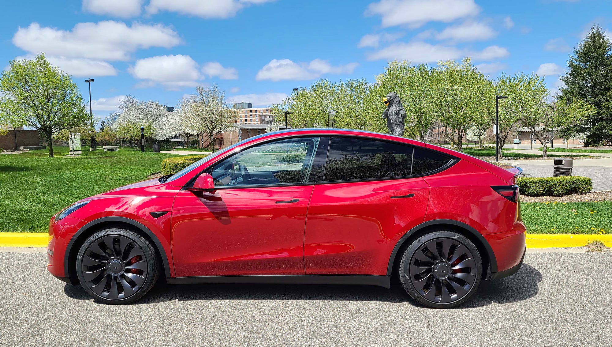 On the Oakland University campus, the Tesla Model Y social-distances from the Oakland bear mascot.