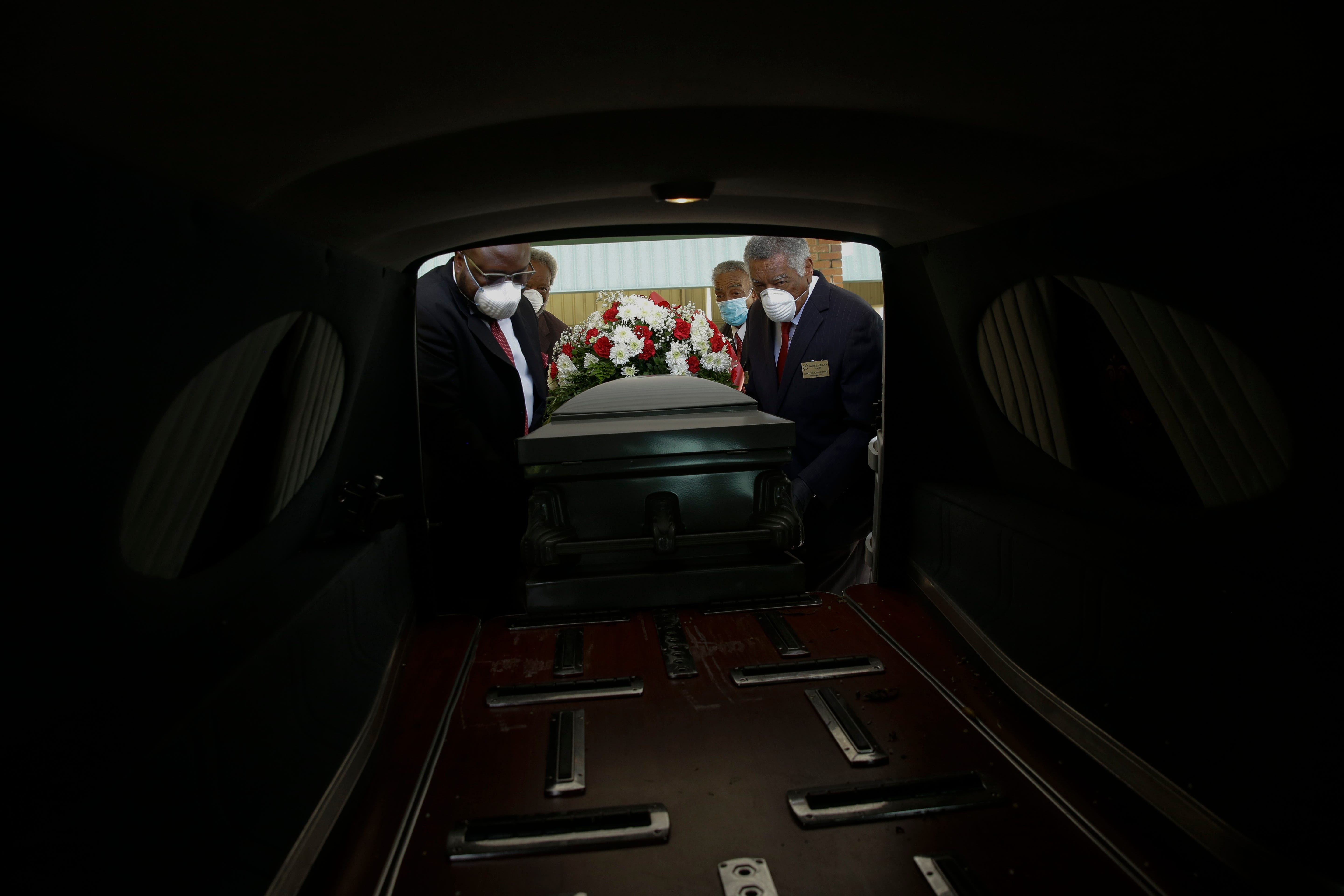 Mortician Cordarial O. Holloway, foreground left, funeral director Robert L. Albritten, foreground right, and funeral attendants Eddie Keith, background left, and Ronald Costello place a casket into a hearse on Saturday, April 18, 2020, in Dawson, Ga. Across the county, the latest Associated Press analysis of available state and local data shows that nearly one-third of those who have died are African American, with black people representing about 14% of the population in the areas covered.