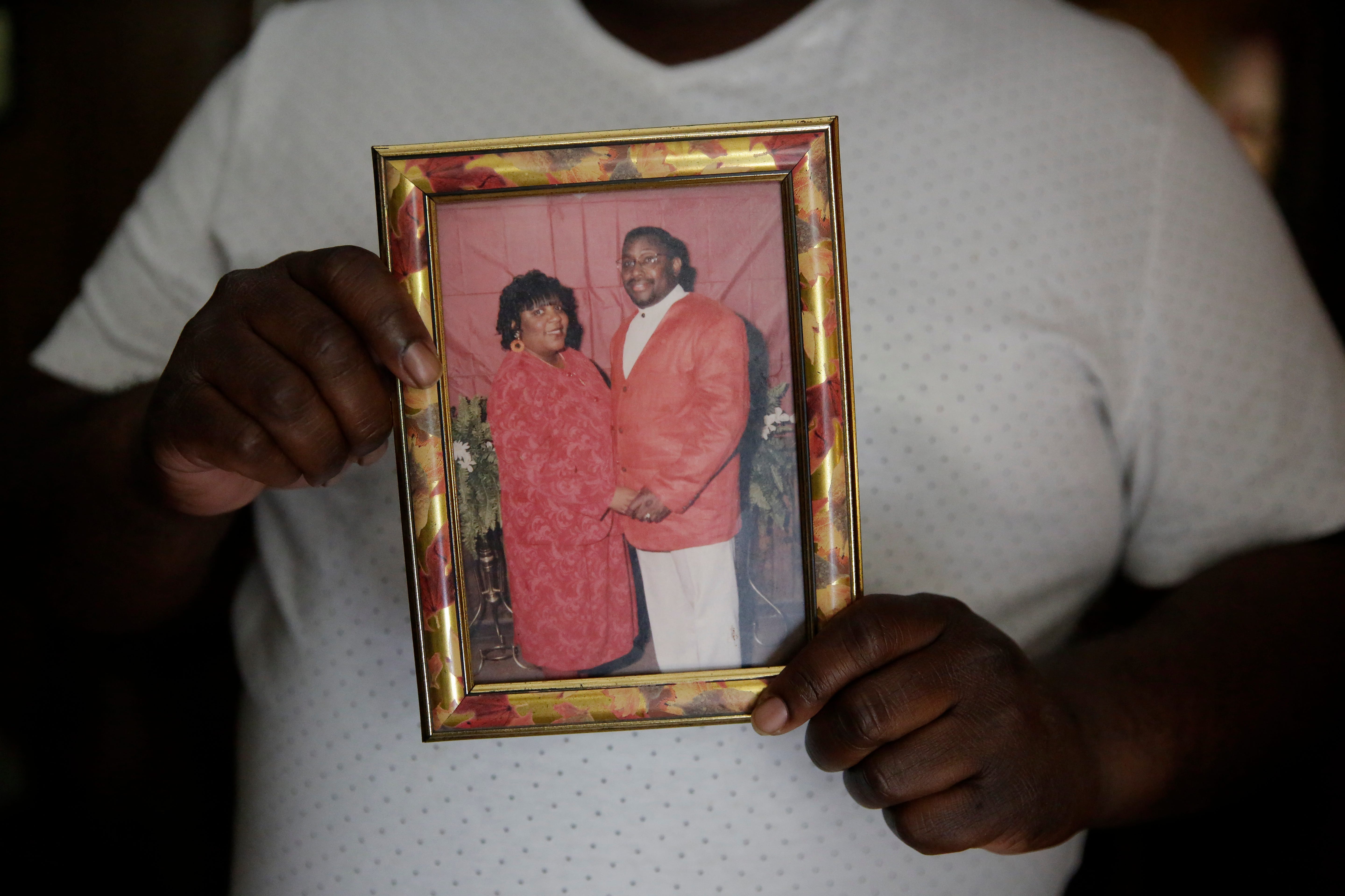 Desmond Tolbert holds a photograph of his parents, Nellie "Pollye Ann" Mae and Benjamin Tolbert, on Saturday, April 18, 2020, in Dawson, Ga. Pollye Ann and Benjamin both died of COVID-19 two days apart.