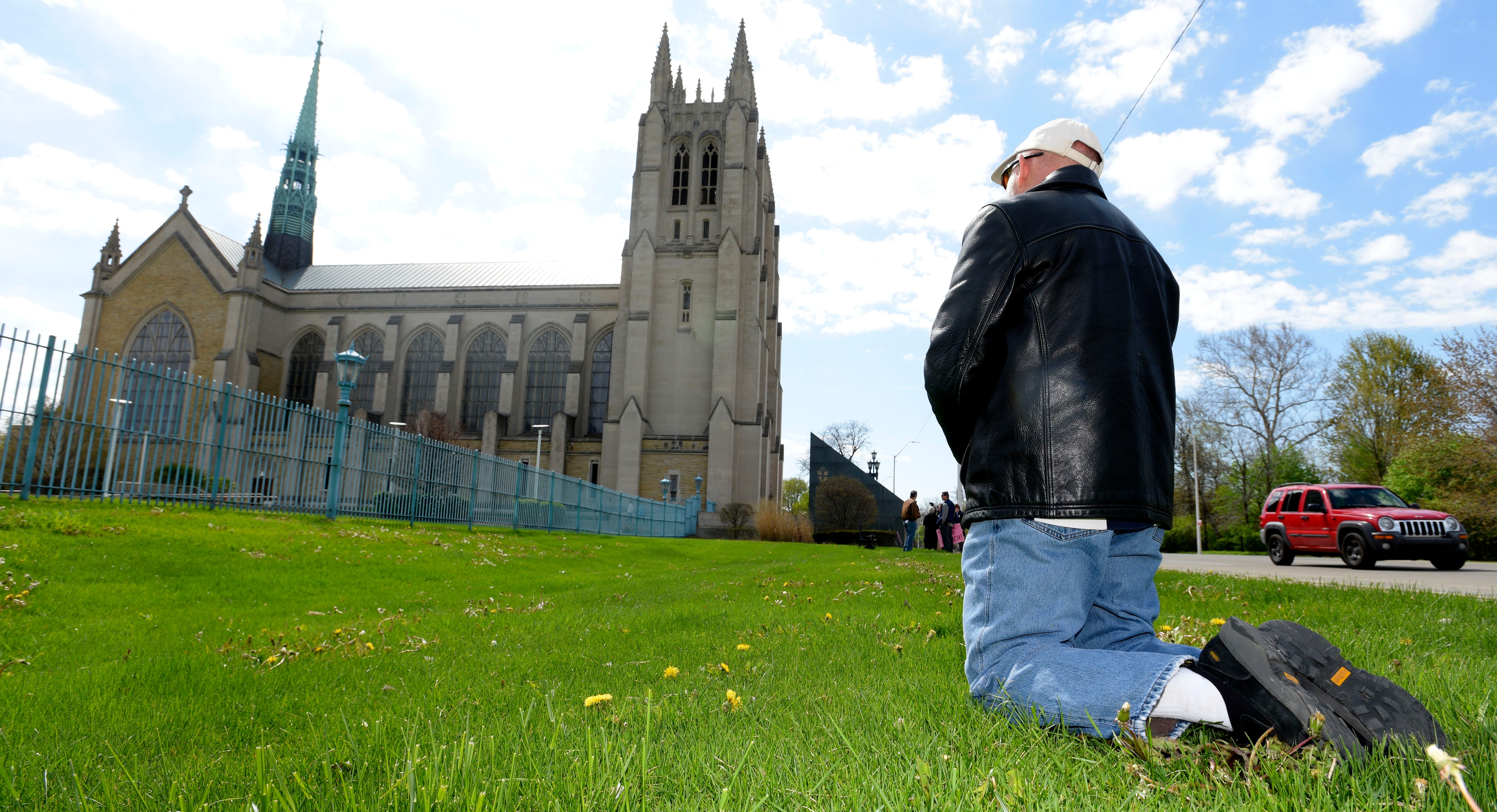 Barry Doherty, of Ortonville, kneels as he Prays the Rosary in front of the Cathedral of the Most Blessed Sacrament on Woodward Ave. in Detroit.