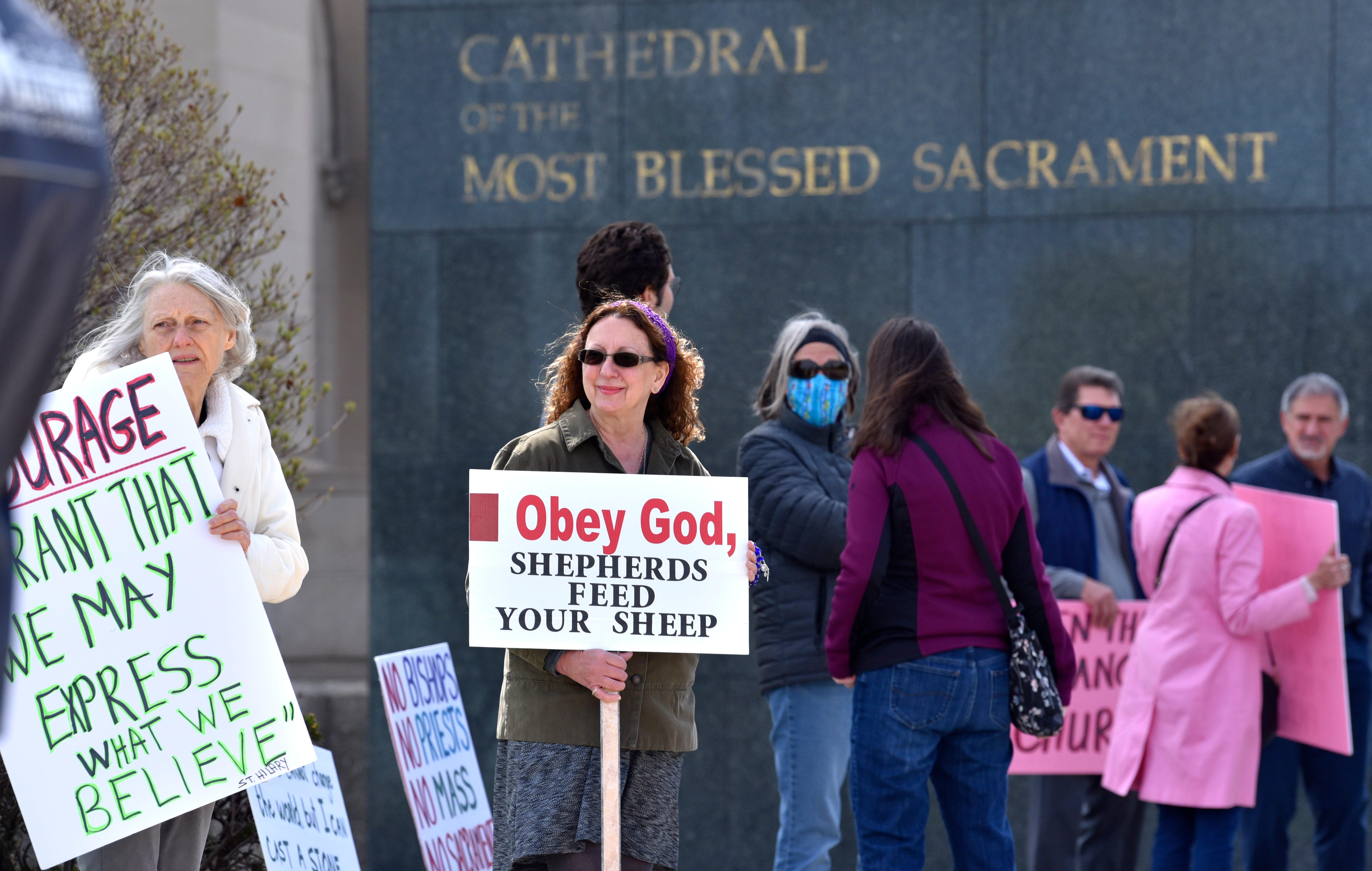 Carol Dumbrell, left, of Hazel Park, and Sally (who would not give her last name) hold signs in front of the cathedral.