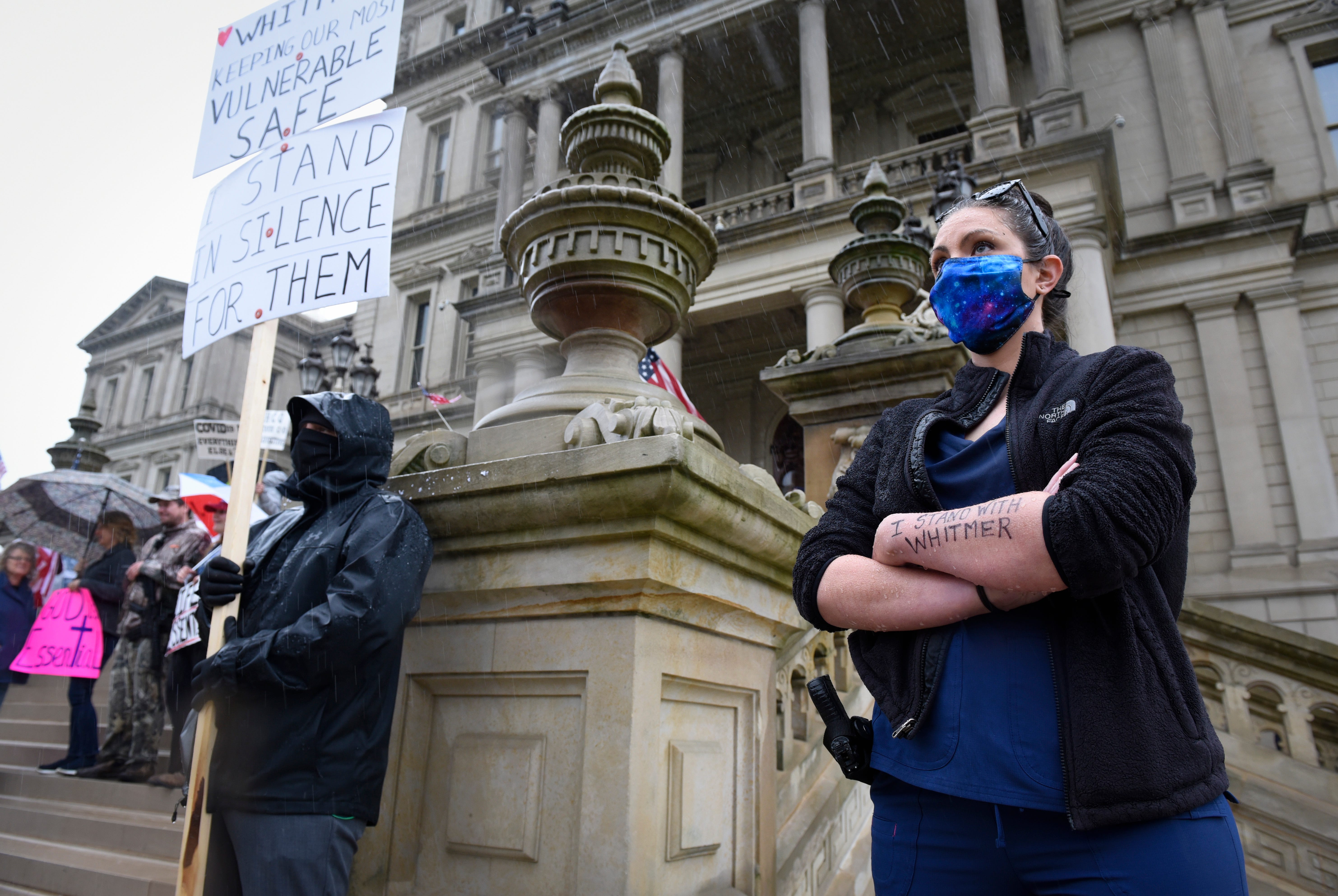 Counter protestors stands for Michigan Governor Gretchen Whitmer during a protest at the state Capitol to oppose her executive orders issued in response to the coronavirus pandemic.