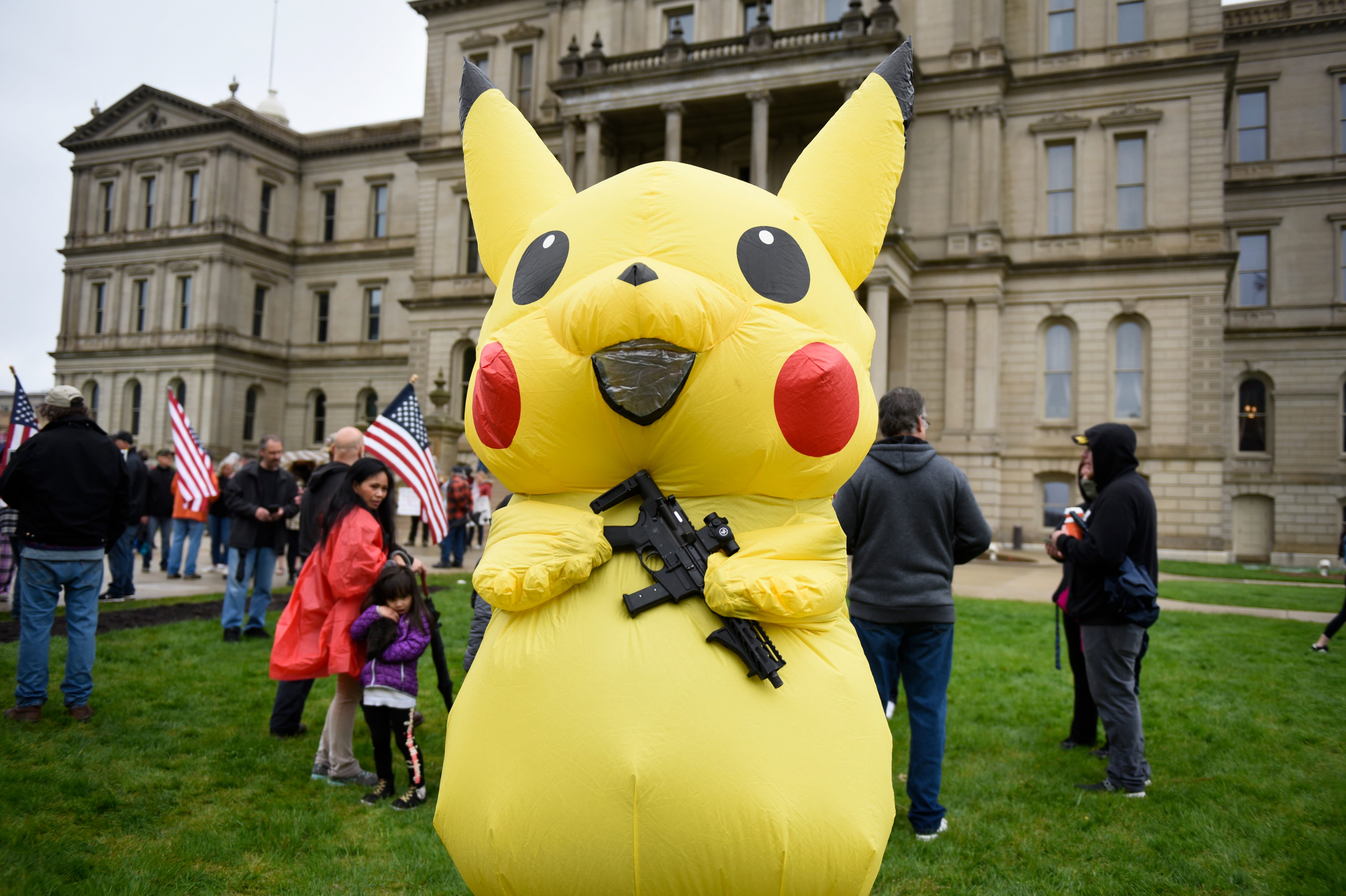 A large Pikachu holds an AR-9 assault-style gun during a protest at the state Capitol to oppose the executive orders Gov. Gretchen Whitmer issued in response to the coronavirus pandemic, Thursday, May 14, 2020.