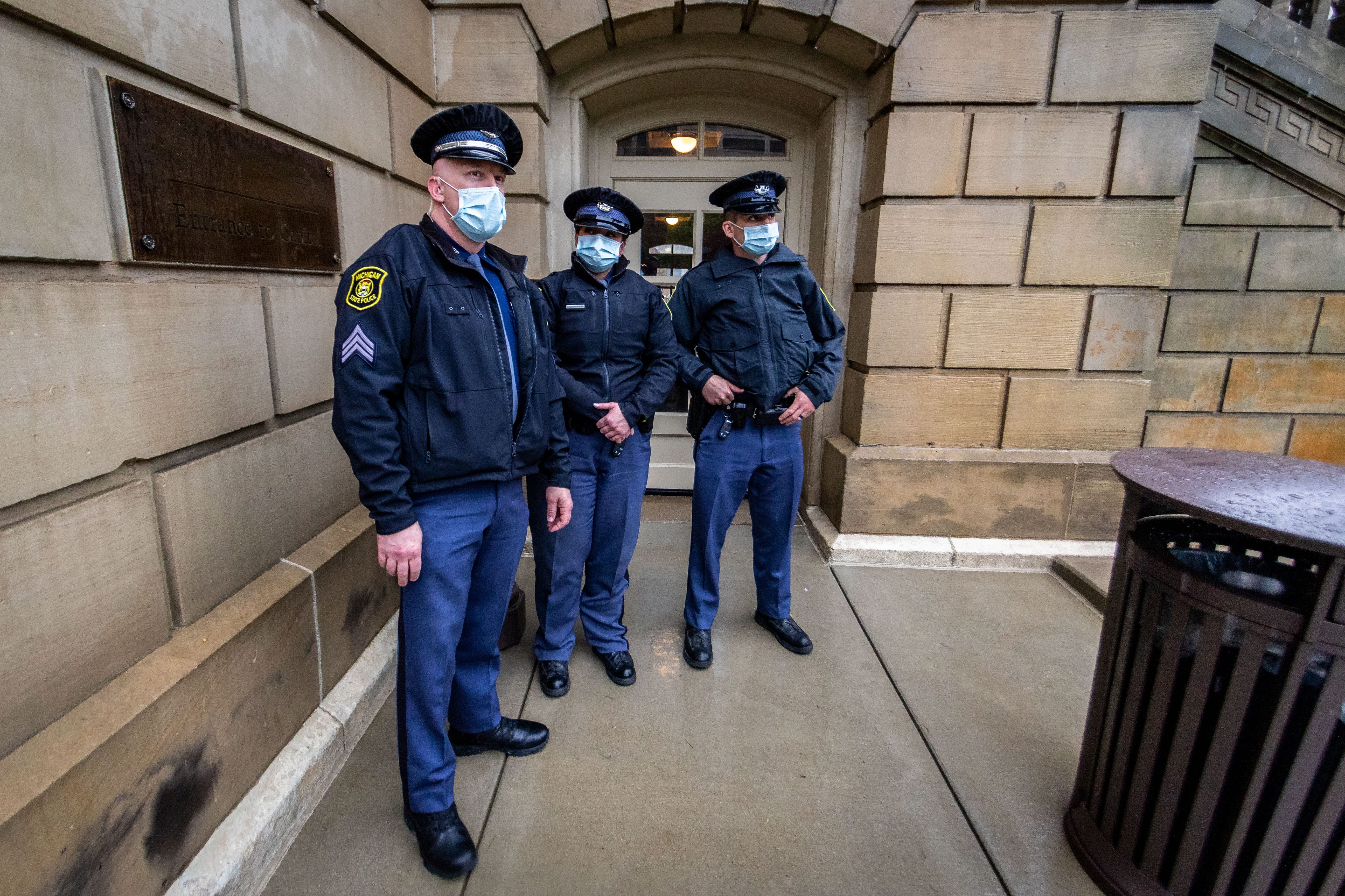 Michigan State Police stand guard at the lower entrance to the Capitol building.