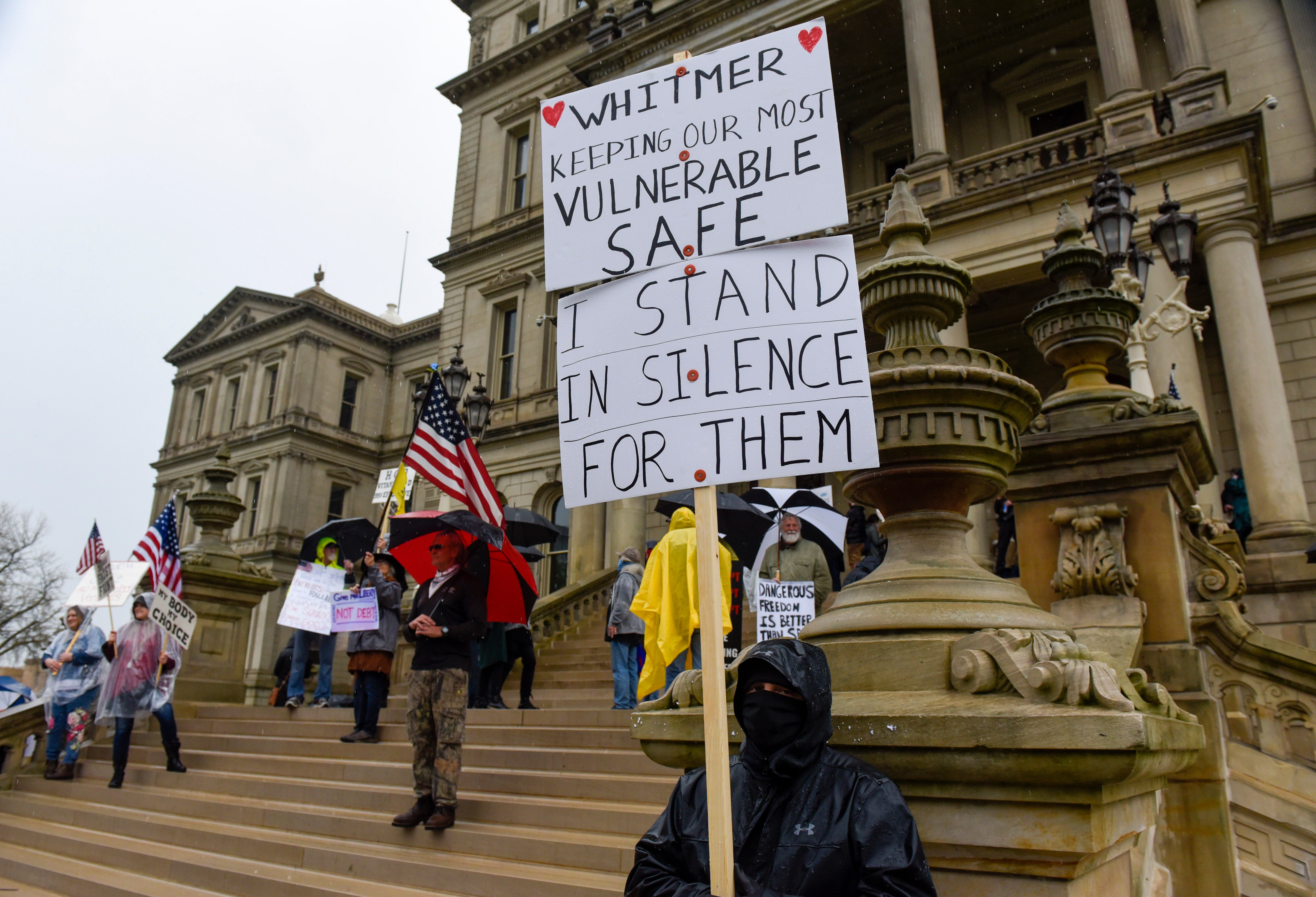 A counter protester stands for Michigan Governor Gretchen Whitmer during a protest at the state Capitol to oppose the executive orders in response to the coronavirus pandemic.