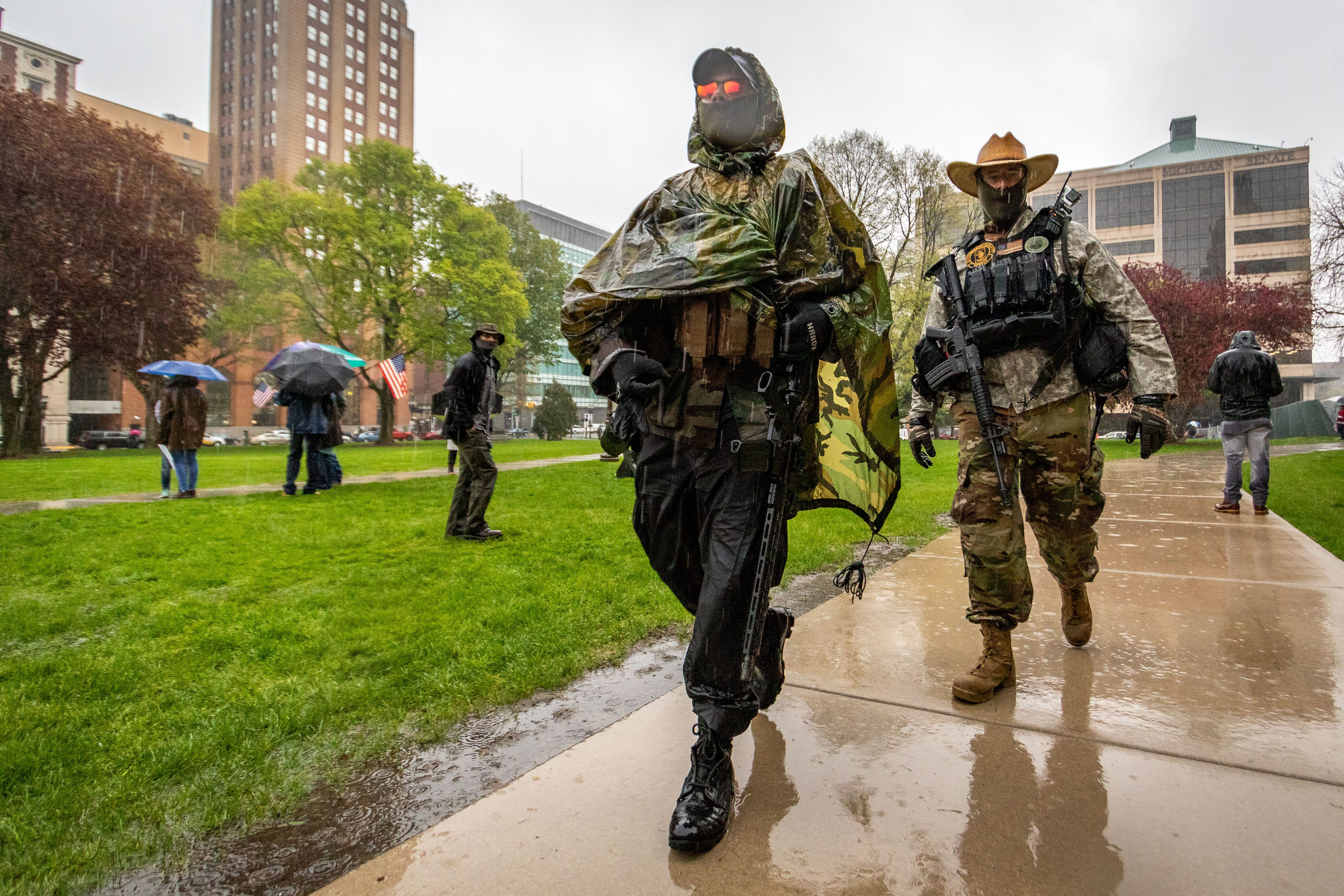 Protesters wearing military fatigues, with weapons strapped across their bodies descend on the Michigan Capitol Thursday to oppose the executive orders Gov.Gretchen Whitmer issued in response to the coronavirus pandemic.