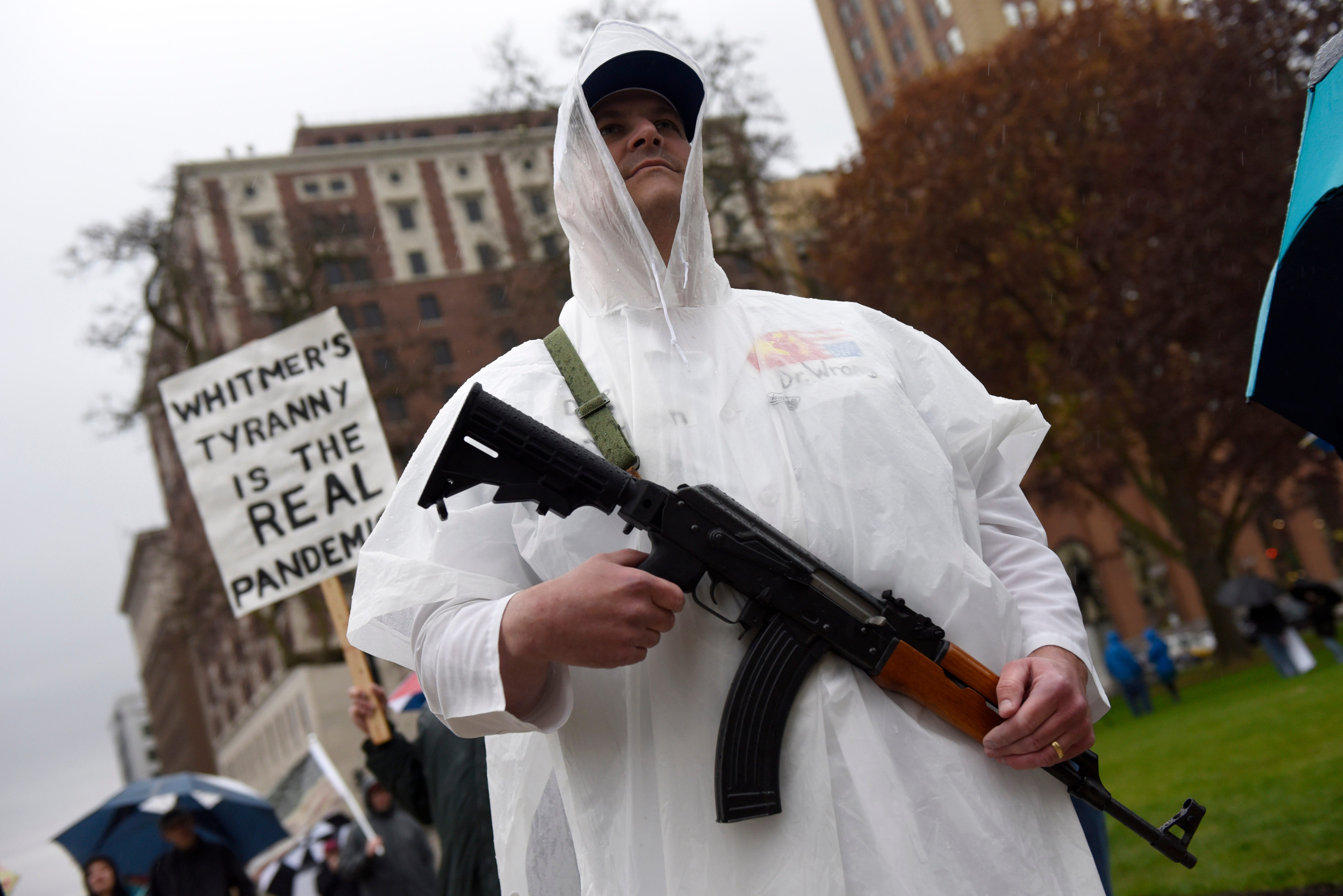 Craig Ladyman of Rockford holds his rifle during a protest at the state Capitol to oppose the executive orders Gov. Gretchen Whitmer issued in response to the coronavirus pandemic, Thursday, May 14, 2020.
